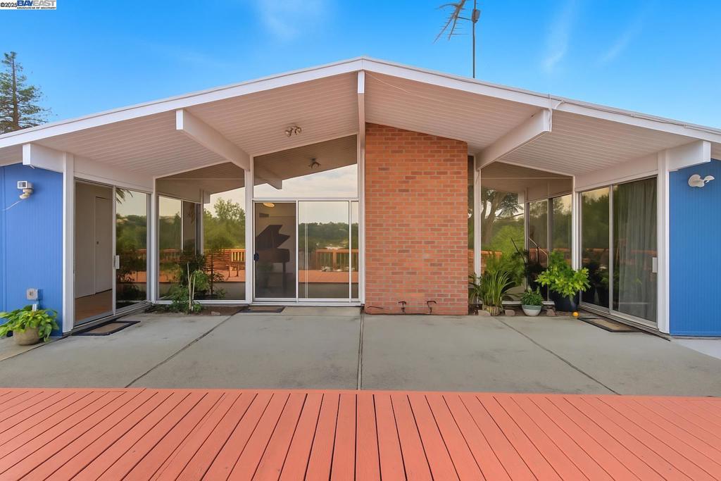 Rarely available Eichler with breathtaking views of the surrounding hills! At night, the sparkling lights across the hills create a magical backdrop. This mid-century modern home retains many original Eichler features, including an open floor plan, floor-to-ceiling glass walls, skylights, and a cozy wood-burning fireplace. Radiant floor heating, connected to an updated tankless water heater, ensures year-round comfort. Attached 1-car garage and carport provide easy, weather-protected parking. The suite-style primary bedroom includes a walk-in closet and a split bathroom that connects to a bedroom or office, offering the perfect setup for a work-from-home professional. Natural light fills every room. The outdoor large deck thoughtfully designed for relaxation and entertaining. The newer foam roof was updated in 2022 with 10-year transferable warranty. A major renovation in 2012 included a remodeled kitchen, flooring, landscaping, concrete pavement, spacious deck, a retaining wall and more. Don't miss this opportunity to own a piece of architectural art!