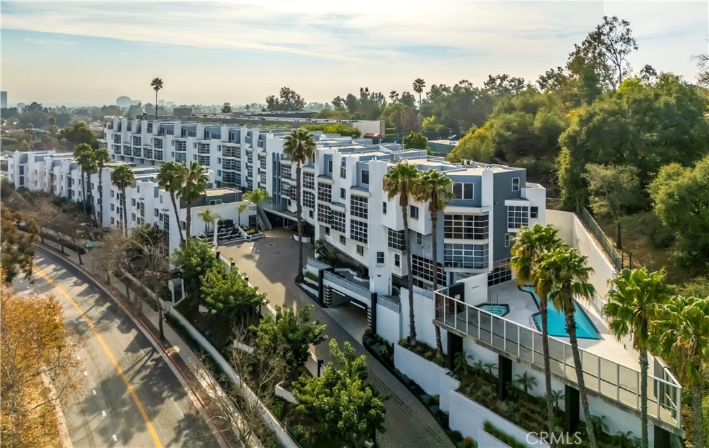 LUXURY BRENTWOOD CONDO LIVING W/ VIEWS
Welcome to this beautifully updated condo in the heart of Brentwood, offering luxury living with sweeping tree-top views of Bel Air, Century City, and city lights. The open layout in the living and dining areas features coffered ceilings, designer lighting, upgraded flooring, and floor-to-ceiling windowed solarium that floods the home with natural light. An electric fireplace adds warmth and charm to the space. The remodeled kitchen is both stylish and functional, boasting quartz countertops, custom cabinetry, floating shelves, modern stainless steel appliances, and a large sink. The spacious primary suite includes dual custom Elfa closets and a luxurious bathroom with soaking tub, separate shower, and upgraded fixtures. A second bedroom suite features a private entrance, large patio, open closet system with built-in drawers, and its own en-suite bathroom with separate vanity area. The laundry area is conveniently located between the bedrooms with an upgraded large-capacity washer and dryer. This secure, well-maintained community offers excellent amenities, including gated entry with 24-hour camera surveillance, elevator and handicap access, two individual parking spaces, ample guest parking, private storage unit, pool, spa, sauna, and fitness center. Ideally located near Brentwood shops, restaurants, UCLA, public transportation, freeway access, and zoned for the highly-rated Kenter Canyon Elementary School, this home combines comfort, convenience, and the best of Westside living.