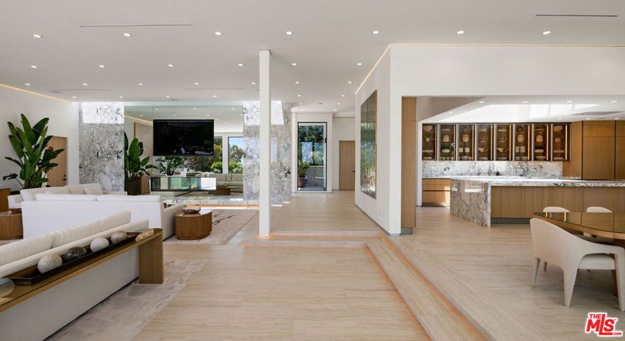 Newly completed construction. Stunning Modern Estate in Coveted Trousdale Estates. Commanding a prime position on one of Trousdale's most desirable streets, this newly completed modern masterpiece offers refined luxury with elegant design, elevated living, and sweeping city light views. Currently being furnished and available July 1st, this estate sets a new standard for sophisticated hillside living. A private, gated entry leads to expansive living spaces with soaring ceilings and walls of glass that frame soft, panoramic city vistas and bathe the home in natural light. The open-concept floor plan creates a seamless flow between indoors and out, ideal for both grand entertaining and relaxed everyday living. At the heart of the home, a state-of-the-art chef's kitchen is equipped with premium appliances, custom cabinetry, and a large island  perfect for hosting or intimate evenings at home. Step outside to a tranquil outdoor oasis featuring an infinity-edge pool, multiple lounge areas, and thoughtfully designed landscaping for ultimate privacy and ambiance. The luxurious primary suite offers a spa-inspired bathroom, large walk-in closet, and serene views stretching across the city. A private screening room, guest suites, and smart home technology complete this rare offering. Available fully furnished or unfurnished, this exceptional Trousdale residence delivers privacy, prestige, and timeless modern design.