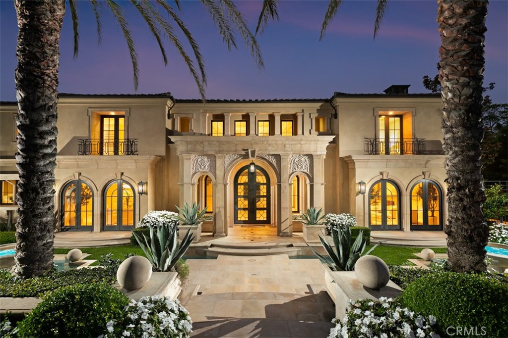 Situated within the prestigious guard-gated community of Pelican Crest, this remarkable custom estate offers approximately 10,310 square feet of refined modern European living, seamlessly blending timeless architecture with contemporary sophistication. Beyond the grand double glass-and-iron entry doors, a dramatic two-story foyer with a sweeping floating staircase and French limestone flooring sets the tone for the home’s exceptional transitional design. Light-filled formal and casual spaces flow effortlessly, including a formal dining room with access to the grounds and a gourmet chef’s kitchen appointed with Viking and Miele appliances, custom cabinetry, and elegant stone surfaces. The great room, anchored by a striking onyx fireplace and sophisticated wet bar, opens through three sets of French doors to the resort-like backyard, creating a natural extension of indoor and outdoor living.
The lower level is dedicated to leisure and wellness, offering a steam room, sauna, gym, temperature-controlled wine cellar, and a state-of-the-art home theater with an adjoining lounge/game area. Upstairs, the luxurious primary suite features a spacious sitting area and spa-inspired bath with dual showers, under-lit onyx countertops, and a deep soaking tub. Additional bedroom suites each include their own beautifully finished bathrooms. Outdoors, the residence’s modern European influences are expressed through symmetrical design and the elegant use of thoughtful materials, creating a private resort setting complemented by breathtaking canyon and peekaboo ocean views. The grounds showcase an infinity-edge pool, spa, fire pits, multiple fountains, and two built-in BBQs—an idyllic backdrop for both intimate gatherings and grand-scale entertaining. All within minutes of Pelican Hill Resort, world-class beaches, fine dining, award-winning schools, and luxury shopping, this estate embodies a rare fusion of sophisticated modern European style and the best of California coastal living.