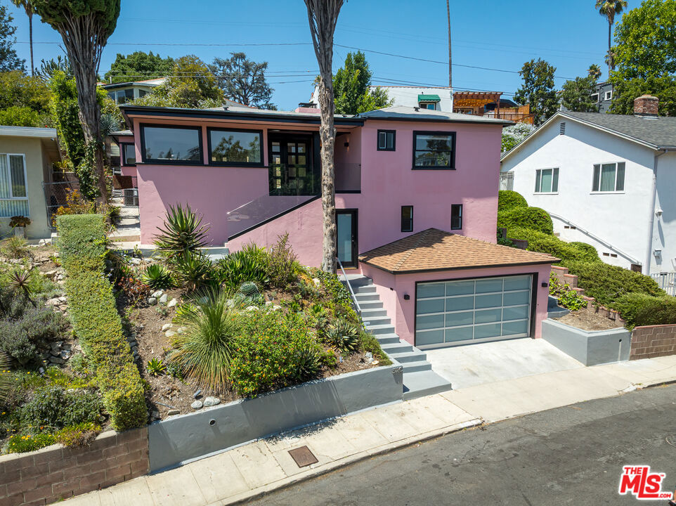 Set on a peaceful street in the coveted Silver Lake Hills, this designer-renovated residence offers a private escape in the heart of Los Angeles. The open, airy floor plan is infused with a subtle Mid-Century sensibility, where every room connects seamlessly to outdoor living spaces. Winding steps lead to a spacious upper yard with sweeping vistas, the perfect backdrop for entertaining or unwinding. The home's many thoughtful upgrades include a gourmet kitchen with premium appliances, a gas fireplace, updated plumbing and electrical, and eco-conscious features such as bamboo flooring, a tankless water heater, and a high-efficiency HVAC system. A finished lower-level bonus room of approximately 300 square feet offers flexible space for a studio, office, or guest room. All this, just moments from the vibrant cafs and shops of Sunset Junction and leisurely strolls around the reservoir.