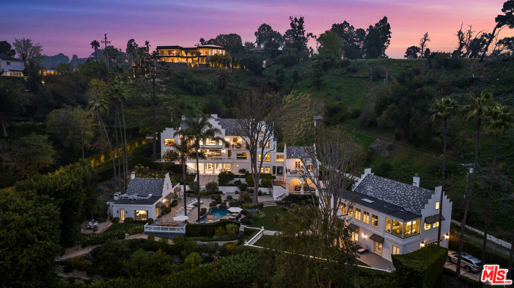 A breathtaking gated estate & compound majestically sited on nearly an acre lot, reminiscent of a villa in the south of France. Every detail has been completely remodeled with the finest level of taste, style, and sophistication. True resort living at its finest featuring 3 separate structures, a stunning main residence with 5 bedrooms, den, family room, library, multiple fireplaces, vaulted ceilings, and expansive loggias with head on views and lush gardens. Separate pool side theatre/media building with professional screening room & office, plus a full 2-bedroom guest house with soaring ceilings, living room with high beamed ceilings, dining room, office, full kitchen, and professional gym/wellness, all overlooking gorgeous city to ocean views. Spectacular gardens, large lawn, and a resort-like swimming pool complete the estate. An incredible package. Shown to pre-qualified clients only.
