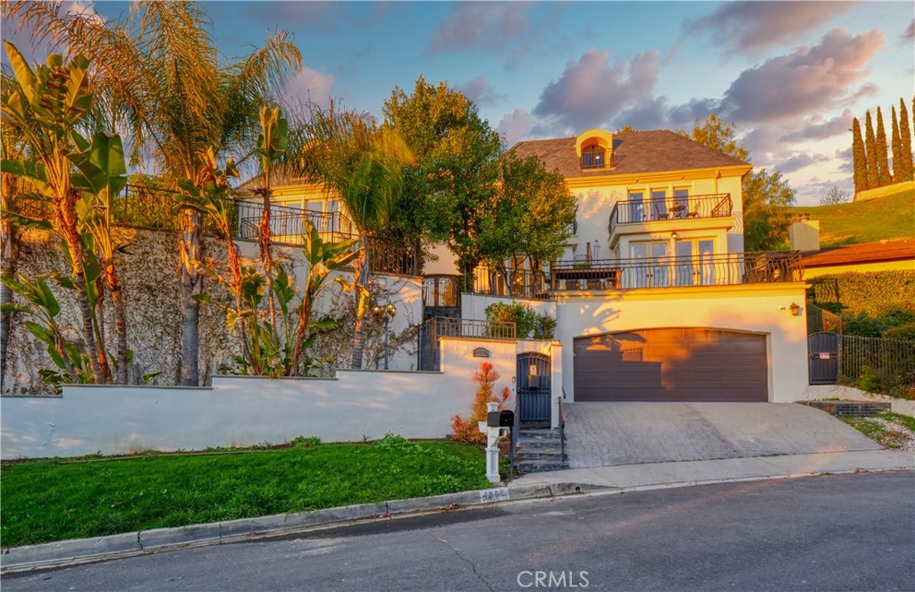 Priced to Sell! This spectacular, one-of-a-kind estate is nestled on the highly coveted Galendo Street in Woodland Hills–South and showcases breathtaking views that are truly without equal. As you enter through the private security gate, the estate’s stunning setting will immediately take your breath away. From the many expansive viewing decks and balconies, enjoy panoramic vistas of the rolling hills—perfect for watching both sunrise and sunset in a tranquil, unforgettable atmosphere. Boasting 5,481 square feet of meticulously upgraded living space, this estate blends architectural elegance with luxury finishes at every turn. Just moments from the community’s exceptional amenities, the home offers an unrivaled combination of location, style, and spectacular views. Step through custom French doors into a beautiful foyer that sets the tone for the rest of the home. The main floor features a spacious living room with elegant fireplace, formal dining room, inviting family room with a cozy fireplace, and a chef’s gourmet kitchen complete with an oversized pantry, central island, perfect for entertaining in style. On the lower level, adjacent to the oversized garage, you’ll find a generous laundry room and a dedicated wine cellar. Take the custom elevator to the bedroom level, where five generously sized bedrooms await, including a luxurious primary suite thoughtfully positioned for privacy and comfort. Each suite offers its own distinctive charm and custom design. The top floor provides the ideal space for hosting guests in a private suite with a full bathroom—or it can easily serve as a home office or creative retreat. Outdoors, the entertainer’s yard is a true highlight, with an inviting courtyard, multiple decks for enjoying the views, al fresco dining areas, and charming sitting nooks throughout. Extending from Galendo Street to Arcos Drive, the property includes a second security-gated entrance that leads directly to the top-floor guest unit, offering ultimate convenience and privacy. This exceptional estate is the epitome of stylish comfort in a prime, private location—with stunning views that elevate everyday living. A rare opportunity to own a truly remarkable home!