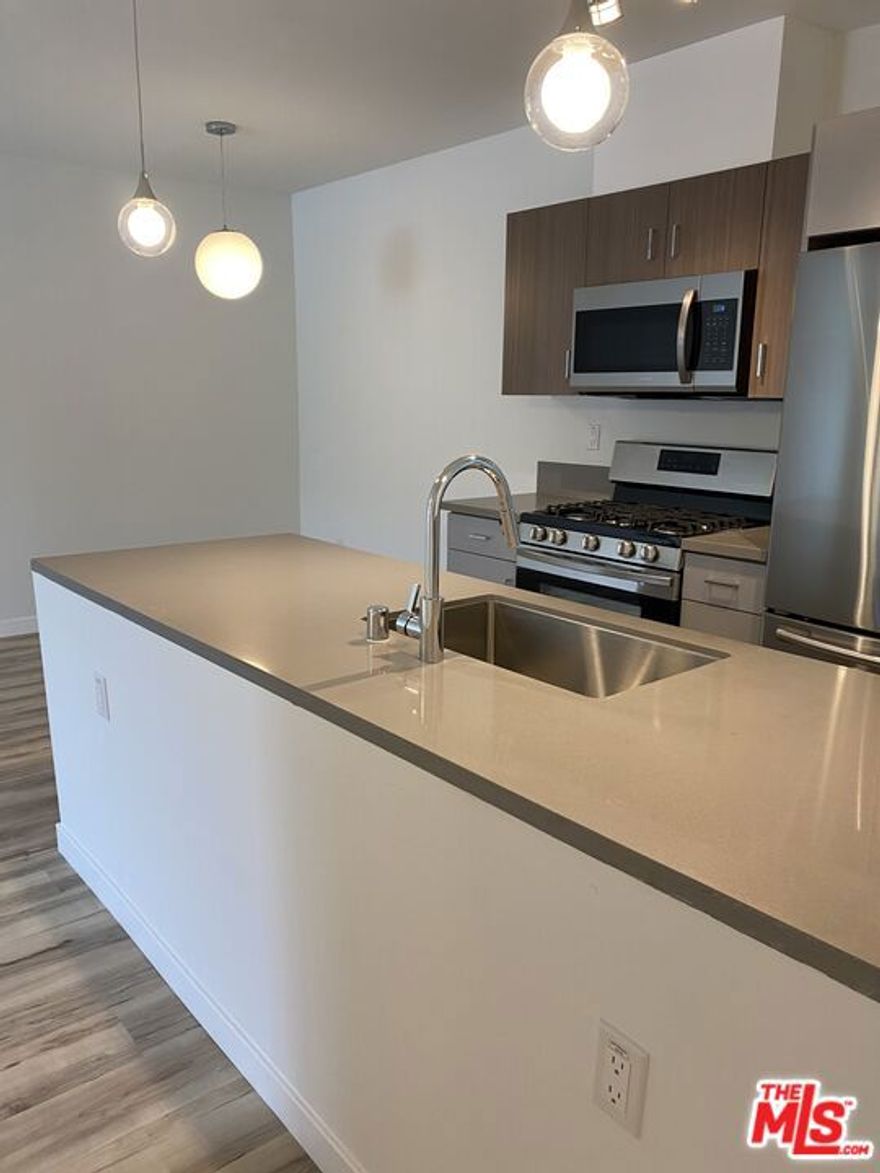 Welcome to this spacious top-floor apartment offering serene views overlooking the community pool. This larger 1-bedroom, 1-bathroom unit features an open and airy layout, with a kitchen island that enhances the modern feel. Updated in 2020, the apartment boasts hardwood floors throughout and a tile bath for added elegance. The kitchen is equipped with stainless steel appliances, including a refrigerator, stove/oven, microwave, and ice maker. Enjoy the comfort of HVAC, the convenience of assigned gated parking, and the flexibility of a pet-friendly community. With a private balcony, gated entry, on-site pool, and laundry room, this is the perfect blend of comfort and convenience in a prime location near Balboa Park and Lake Balboa/Van Nuys.