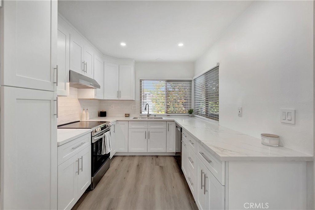 This beautifully remodeled condo is waiting for you! The kitchen has brand new solid wood cabinets with soft close doors along with stainless steel appliances and sink. Beautiful new quartz countertops and tile backsplash. Open floor plan with a spacious living and dining area. Beautiful new Luxury Vinyl Plank flooring throughout. There's a walk in laundry room with cabinets for extra storage. The bathroom has a brand new sink and vanity. The shower and bathtub is also new with beautiful tile. The primary bedroom is spacious and has a walk in closet with built ins for extra storage. The second bedroom is spacious with an attached closet. All the windows and screens are brand new and keep outside noise out. A brand new air conditioner has also been installed and is set up with a Nest system so you can turn it on and off with your phone. This is an upper unit that is by itself so you don't share any walls. There is a cozy patio in the front of the unit that is good for sitting outside or having a BBQ. Directly below the condo is 2 designated parking spaces with 6 large storage cabinets. This is going to go fast!