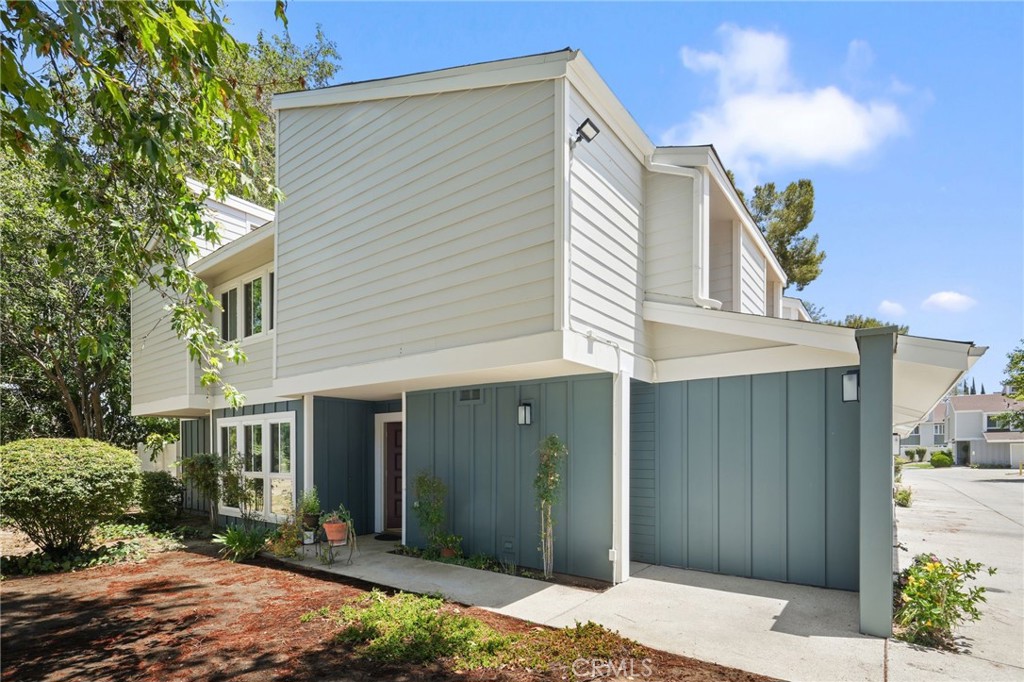 Welcome to this model perfect end-unit located in the coveted Northridge Townhome Estates Community! This beautifully maintained two-story townhome offers the perfect blend of privacy, space, and modern living, with only one shared wall and over 2,000 square feet of thoughtfully updated interior space. This 3 bed, 2.5 bath home exudes warmth and character, combining traditional charm with tasteful modern upgrades to create a true sense of home. As you enter, you're greeted by a bright, open layout filled with tons of natural light. The spacious dining area flows seamlessly into a pristine kitchen featuring stainless steel appliances, custom built-in cabinetry, recessed lighting, and a sliding glass door that opens to a serene patio—ideal for al fresco dining or morning coffee. The generous living room is highlighted by a modern fireplace, recessed lighting, and another large slider that leads to the fenced private outdoor space with newer vinyl fencing, offering both comfort and seclusion. A stylishly updated half bath and gleaming wood floors throughout the dining, and living areas complete the inviting first floor. Upstairs, a large, sunlit loft provides a flexible bonus space—perfect for a family room, home office, playroom, or a potential fourth bedroom. The spacious primary suite boasts vaulted ceilings, recessed lighting, and a luxurious en-suite bathroom with a custom double-sink vanity with granite countertops, a soaking tub, and a separate glass-enclosed shower. Down the hall are two additional generously sized bedrooms that share a full updated bathroom with dual sinks. Additional features include a private two-car garage with direct access, a convenient in-unit laundry area, recessed lighting throughout, and picturesque views of mature trees and park-like surroundings as the unit is situated at the back of the community. The HOA offers an impressive array of amenities, including swimming pools, gym, tennis courts and clubhouse! Water, basic cable, internet and trash are also included!! Located in the Granada Hills Charter High School area. This move-in-ready home is a rare opportunity in one of Northridge’s most sought-after communities.