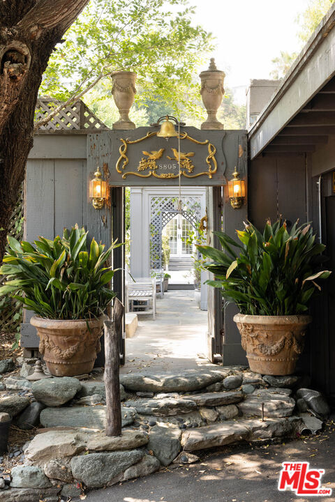 Hidden up a long, private drive, "Pebble Court" reveals itself like a secret from another time. Once the home and studio of artist and award-winning costume designer, Theodora Van Runkle best known for Bonnie and Clyde, The Godfather II, Myra Breckinridge and other major films, this enchanting jewel box compound radiates creativity, legacy, and magic. Perfectly situated on over 1/3 acre, the land is remarkably flat - a rare find in Laurel Canyon. The main residence feels timeless and ethereal, boasting a beautifully updated kitchen and primary bathroom adorned with original details, stained glass, and elegant finishes. An attached artist's studio is marvelously set at the base of a 30-foot wine barrel, and a separate casita offers a serene retreat for guests. The grounds are whimsical and magical; a nature sanctuary where imagination knows no bounds. New outdoor kitchen, enchanting archways and paths, expansive decks with sweeping canyon views and paved, off-street parking for several cars make for effortless entertaining. Previously a social haven for cultural luminaries such as Joni Mitchell, Jim Morrison, Frank Zappa and John Lennon, this home has captivating creative energy that still lingers in the air. Whether seeking a peaceful retreat, space to collaborate, or a unique blend of nature and urban convenience, this property has it all. Located in the Wonderland School District with easy access to the vibrant Sunset scene, Hollywood Blvd, Mulholland, Ventura Blvd, and Studio City. A diamond in the rough, this is an opportunity rarely found and not to be missed!