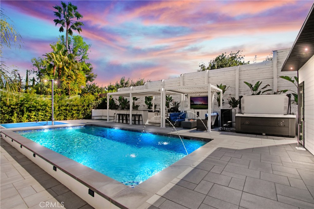 WELCOME TO YOUR NEW DREAM HOME in the prestigious Carlton Terrace neighborhood of Woodland Hills, where modern luxury meets effortless California living. This fully gated and beautifully updated estate offers dual living spaces and a resort-style backyard oasis designed for comfort, entertainment, and relaxation. The main residence features three spacious bedrooms and two bathrooms with a bright, open floor plan that flows seamlessly from living to dining areas. A versatile bonus room is perfect for a home office, yoga studio, or creative space. A separate recreation room with its own private entrance and full bathroom offers endless possibilities, ideal for a studio, guest suite, or wellness retreat. Adding to the flexibility of the property is a 485-square-foot private Junior ADU with its own address, offering one bedroom, one bathroom, in-unit laundry, and upscale finishes—perfect for extended family, guests, or additional rental income. The sun-drenched backyard is a true showstopper, featuring a heated pool, jacuzzi, cold plunge, cedar sauna, private pickleball court, and a putting green. The custom marble outdoor kitchen includes a built-in barbecue, Italian pizza oven, fire pit, outdoor TV, and a luxurious outdoor bathroom and shower—creating the perfect setting for year-round entertaining and relaxation under the stars. Solar panels provide energy efficiency, and the gated driveway offers secure parking with space for multiple vehicles, along with an EV charging station. Ideally located just minutes from the Topanga Westfield Mall, Pierce College, Warner Center, Kaiser Permanente, top-rated schools, and the area’s best beaches and hiking trails, this property offers an unparalleled lifestyle of beauty, comfort, and convenience. Whether you're looking to host unforgettable gatherings or escape into your own private paradise, this one-of-a-kind estate is your opportunity to live the California dream. Buyers to assume solar lease. CALL TODAY, THIS WILL NOT LAST!