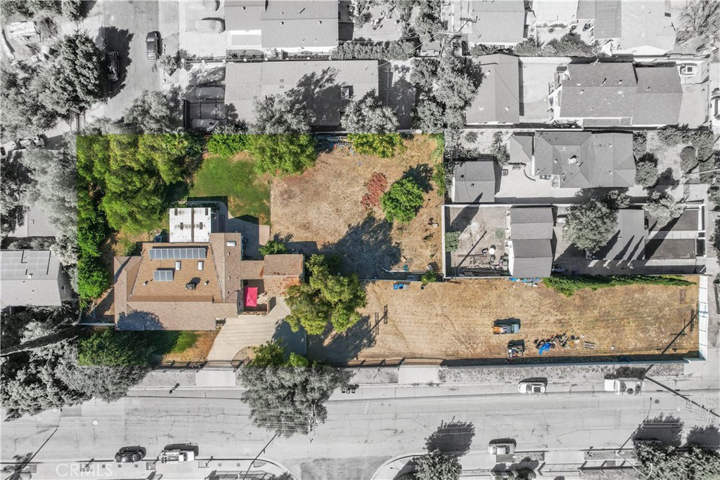 Welcome to this spacious 2,533 sq ft home tucked away in the Foothills of Sylmar, just north of the 210 Freeway. Situated on a sprawling 33,000 sq ft lot, this property offers ample space for horses, outdoor living, or the potential to split the lot under SB9 for additional development (buyer to verify with local ordinances). Step inside to discover soaring vaulted ceilings that create an open, airy atmosphere. The generous dining area flows effortlessly into a large, well-appointed kitchen—perfect for hosting gatherings or everyday family life. Enjoy the comfort of two inviting living spaces, connected by a cozy double-sided fireplace, and a spacious laundry room for added convenience. With four bedrooms, including a flexible 4th bedroom currently used as an office, this home adapts to your needs. The private primary suite is a relaxing retreat featuring a walk-in closet and an en-suite bath. Outside, the possibilities are endless—whether you envision building an ADU, expanding your living space, or designing your dream outdoor oasis. All this, conveniently located near schools, gyms, shops, LA Mission College, and public transportation.