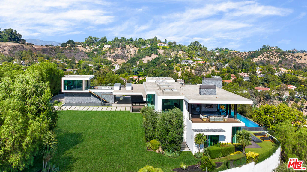Welcome to 3000 Benedict Canyon Dr, a resort-like retreat set on 3.2 acres in the splendor of nature, and one of the finest properties in Beverly Hills. Beyond the estate's secure gates at the end of an exclusive cul-de-sac you experience one of the most jaw-dropping approaches to a home imaginable. Sprawling lawns, dramatic water features, lush greenery, and beautiful vistas frame an architectural masterpiece immersed in natural surroundings. Positioned on a massive promontory lot, the home asserts incredible views from nearly every room. Beyond the light-filled entry with voluminous atrium you experience the ultimate in California living. A chef's caliber kitchen boasts top-of-the-line appliances and peninsula with Hibachi grills, and is the perfect place to prepare farm-to-table meals with fresh ingredients sourced from your hillside gardens. The living room with walls of glass juts out into endless vistas above the hustle and bustle of LA. Enjoy your favorite film in the atmospheric, soundproofed theatre with 4K laser projector. Enhance your healthy lifestyle in the indoor/outdoor gym with dedicated bathroom. Accentuating the bedroom wing is a stunning architectural staircase leading to a comfortable seating area and the sumptuous master suite with fireplace, private balcony, dual walk-in closets, and spa-like bathroom. Each of the ample guest bedrooms opens to the exterior adding to the resort-like experience. The multitude of outdoor spaces include an infinity edge pool and hot tub, numerous patios and outdoor fireplaces, outdoor BBQ, rooftop decks, hillside gardens, and fruit trees. Truly an estate in a class of its own.