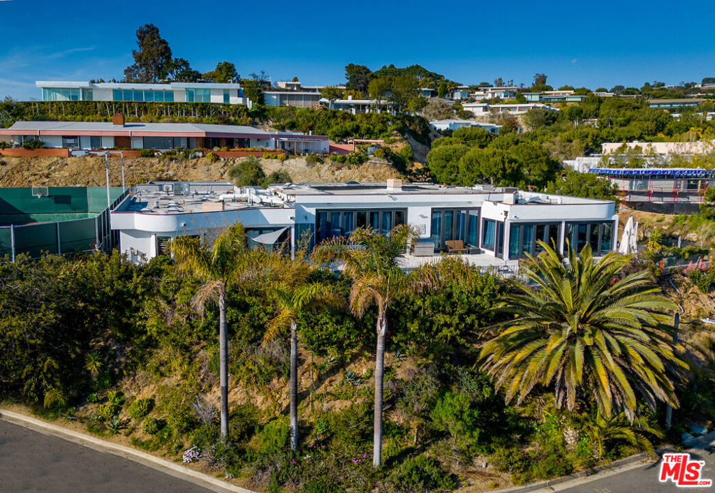 Just reduced by $1 Million! - Court-ordered sale. Tremendous value for this expansive approximately 6000 SF contemporary villa located in the prestigious Trousdale Estates! Home is perched high on a hill up a long private gated driveway and provides a spacious open floor plan and beautiful city and ocean views. Seamless indoor/outdoor flow, walls of glass, and tons of natural light offer a serene oasis for luxurious living. Step through the glass door entry and be greeted by grand scale living spaces featuring soaring ceilings, terrazzo floors, and custom-made mahogany windows. Enormous living room, voluminous family room, and elegant formal dining room are perfect for entertaining guests. The chef's kitchen boasts top-of-the-line stainless steel appliances including Wolf, Miele, and Sub-Zero, granite counters, glass tile, lengthy center island, and large sun-filled breakfast area. Home offers 5 generous bedroom suites, 7 full bathrooms, and 2 powder rooms, providing ample space for family and guests. The huge primary suite features a sitting area, fireplace, glass doors to the yard, 2 walk-in closets and dual baths adorned with onyx and mosaic. The sweeping outdoor space is truly an entertainer's dream, featuring a sparkling saltwater pool, BBQ, fire pit, outdoor shower, and shaded lounge area perfect for relaxing. Additional amenities include a sound-proofed media room, office, wine cellar, bar, sauna, security system, cameras, integrated sound system, recessed lighting, and quality materials throughout. Move-In and enjoy this modern compound as is or update its excellent bones and perfect floor plan to the next level. Minutes away from restaurants, shopping, entertainment, Sunset-Strip and all the amenities Beverly Hills has to offer. A unique opportunity and exceptional value for this highly coveted area!