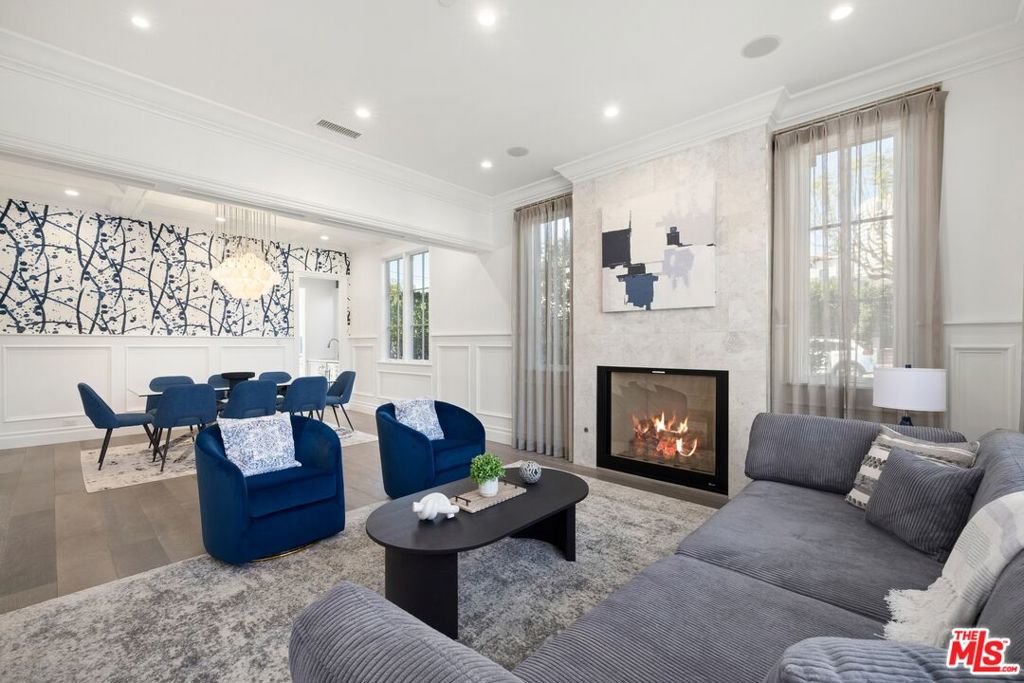 As you step through the front door, light streams in through tall windows, filling the space with a warm glow. The open layout draws you forward, past the formal living and dining rooms, to a kitchen that seems ready for anything from quiet mornings to lively gatherings. Here, premium appliances, a generous center island, and abundant storage come together in perfect harmony. On the main level, a comfortable bedroom with its own bath offers flexibility, perfect for guests, multi-generational living, or simply a peaceful retreat away from the bustle of the upstairs bedrooms. A versatile bonus room also sits nearby, ready to serve as a home office, creative studio, or quiet reading space. The family room flows seamlessly to the outdoors, where a sparkling pool, spa, and outdoor kitchen set the stage for afternoons in the sun or evenings by the fireplace under the stars. Upstairs, each of the four bedrooms offers its own en suite bath, giving everyone a sense of comfort and privacy. The primary suite becomes a place you'll look forward to ending your day, complete with a cozy fireplace, private balcony, oversized walk-in closet, and spa-inspired bath with a soaking tub. To make the move even easier, this home is offered fully furnished, with each space thoughtfully appointed to complement its design and style. Located just moments from Century City, Beverly Hills, and UCLA, this home combines timeless Cape Cod character with modern elegance, offering a setting where every day feels a little more special.