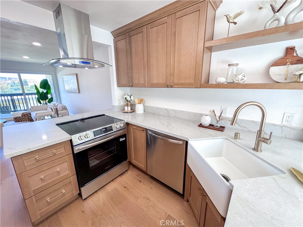 Don’t miss this rare opportunity to own the largest floorplan in the highly desirable Laguna Village community of Laguna Hills. This thoughtfully upgraded 3-bedroom, 2-bathroom condo is move-in ready and filled with natural light. Step into the inviting open-concept main floor, where you’ll enjoy panoramic views from the main-floor balcony. The home features a spacious open-concept with the primary suite conveniently located on the entry level for added comfort and accessibility. It has been extensively upgraded with new shaker style cabinetry and quartz countertops in the kitchen and bathrooms, new dual-pane windows and sliding doors, a new water heater, and a refurbished AC system for year-round comfort. Stylish features like new stainless steel appliances, recessed lighting, and brand-new waterproof engineered wood flooring elevate the modern aesthetic. Downstairs, you'll find two additional spacious bedrooms and a full bathroom—ideal for family, guests, or transforming into a home office, gym, or creative space. A second patio on the lower level extends your living area and offers the perfect spot for outdoor lounging or gardening. A private, enclosed courtyard adds flexible outdoor space or bonus parking, and the direct-access garage with ample guest parking makes everyday living easy. Laguna Village offers resort-style amenities, including pools, a clubhouse, fitness center, tennis and basketball courts, parks, and scenic walking trails. Ideally located just minutes from world-class beaches, premier shopping, dining, and major freeway. Trash and landscaping are included in the HOA. NO MELLO ROOS! This is an unbeatable lifestyle opportunity in the heart of Orange County-come see it before it's gone!
