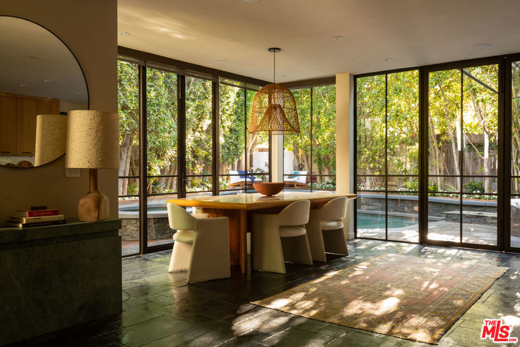 Step into the soulful style of renowned interior designer Kim Gordon - this extraordinary residence was crafted as her own personal sanctuary. Just south of Abbot Kinney and moments from the beach, this home embodies laid-back coastal living elevated by Kim's celebrated panache. From the very foundation, the vision was clear: "Our dedication is unwavering to innovation, to artistry, to harmonious living. All that tomorrow yearns for. Seamless indoor-outdoor integration is our signature, and our mission is to craft spaces where life flourishes." These guiding principles are woven into every inch of the property. Inside, the details unfold with warmth and intention. Heated limestone floors carry you through two serene living spaces into a sun-drenched glass dining room. At the heart of the home, a chef's kitchen with Wolf appliances and an expansive 10-foot island invites gathering, conversation, and connection. Upstairs, four airy bedrooms, each with its own private balcony, embrace the sunlight and ocean breezes. The primary suite is a treehouse-like escape, overlooking verdant gardens, and complete with a spa-level bath featuring an air-chroma therapy tub and dual steam shower. Outdoors, the home opens into a lush private retreat: dine al fresco beneath the stars, relax poolside, or soak in the waterfall hot tub, all cocooned by greenery and calm. A gated entry and secluded front garden create both privacy and serenity, making this coastal haven feel worlds away. Kim Gordon's signature style - effortless, earthy, and entirely unique - resonates throughout this exceptional Venice Beach residence. Rarely does a home so perfectly reflect both artistry and soul.