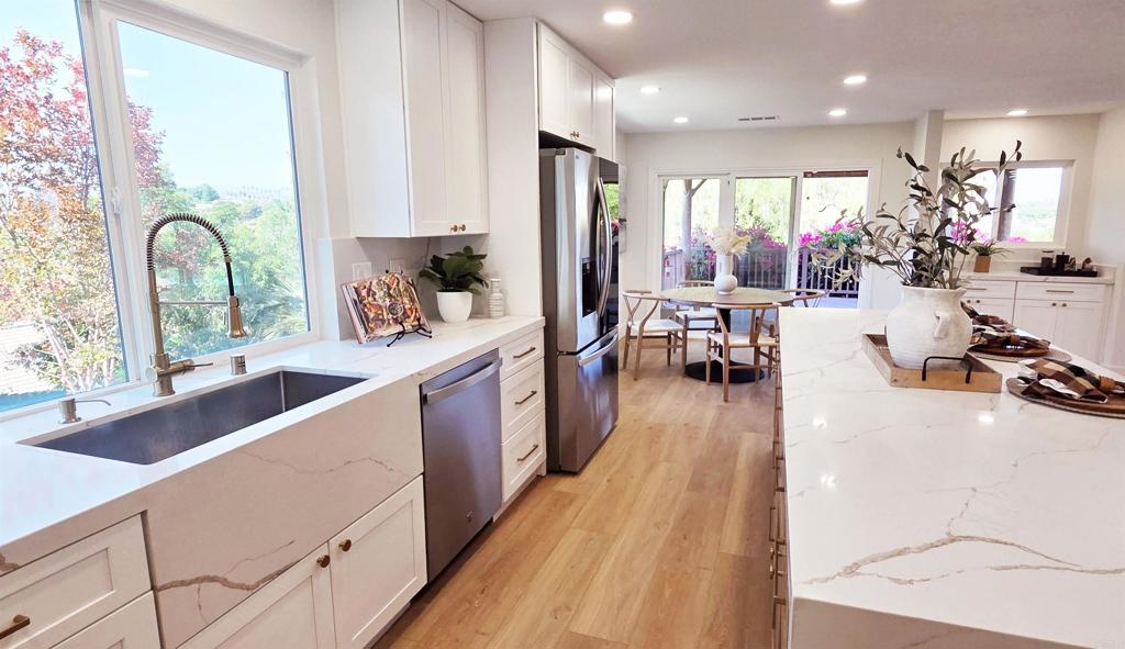 This beautifully updated 4 bedroom, with 3 bathrooms (two 3/4, one 1/2) single-story home is located on a peaceful 0.8-acre lot in Escondido. The entire interior has been thoughtfully renovated with designer finishes, including luxury vinyl plank flooring, quartz countertops, and upgraded bathrooms that bring modern elegance to every space. The open, light-filled floor plan offers a seamless flow between the kitchen, dining area, and great room. The stunning kitchen connects to the main living areas perfect for entertaining family and guests. A cozy fireplace in the great room opens into a secondary living space ideal for relaxing or hosting guests. Step outside to take in the breathtaking backyard complete with a covered patio, sparkling pool, spa, and lush landscaping with amazing views of the hills. Additional features include an attached two-car garage and ample space for extra parking in the driveway, whether for guests or recreational vehicles (RV).