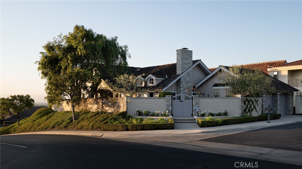 Welcome to 2001 Yacht Resolute, an exceptional customized single-level residence in the guard-gated community of Seaview in Newport Beach. Set on a rare corner lot at one of the community’s premier view locations, the home offers breathtaking city and ocean views.
Enter through a private gated courtyard to an inviting outdoor dining area with a built-in BBQ, perfect for year-round coastal living and entertaining. Inside, discover light-filled living spaces with soaring ceilings, natural wood beams, and a cozy fireplace. The dining room flows seamlessly into the gourmet kitchen, appointed with top-of-the-line appliances, a spacious pantry, and a charming breakfast nook anchored by its own fireplace. The serene primary suite enjoys private sunset views and a spa-inspired bath with dual closets, a soaking tub, and a walk-in shower. Two additional bedrooms with a shared bath provide flexibility for family, guests, or a home office. An expanded laundry room and powder bath complete the thoughtful floor plan.
Additional highlights include beautiful hardwood flooring, fresh interior paint and carpet, refreshed landscaping, ample storage with pull-down attic access, and a two-car garage. A generous wrap-around stone patio extends the living space outdoors, framed by mature trees and lush landscaping that enhance both privacy and beauty offering ample room to entertain guests while taking in the breathtaking views.
With its highly desirable single-level layout and access to Seaview’s resort-style amenities including guard-gated security, pool, spa, and tennis courts, this property presents a rare opportunity just moments from world-class shopping, dining, and beaches.