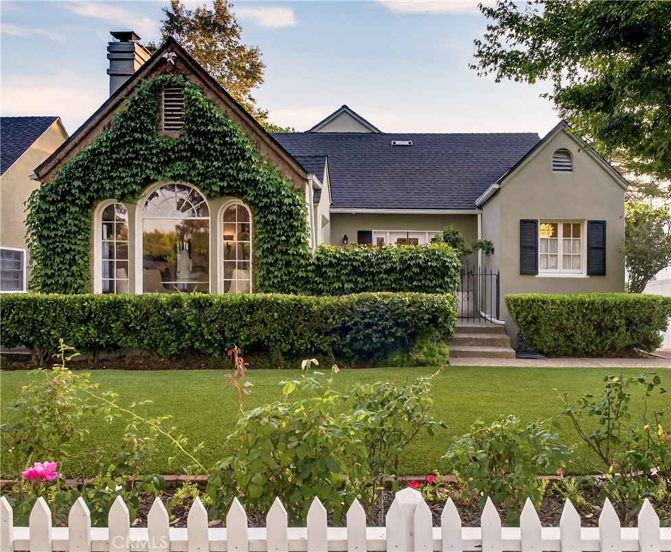 Nestled on a tranquil, tree-lined street in Pasadena’s coveted San Rafael Flats, a classic white picket fence frames this captivating English cottage, harmoniously blending timeless character with modern comforts. The entire second story is dedicated to the serene primary suite, a private retreat featuring abundant natural light, multiple closets, a storage room, and a newly remodeled spa-inspired bathroom complete with a luxurious soaking tub. On the first floor, three additional bedrooms offer flexible space. One currently serves as a guest room, while another functions as a separate home office, ideal for remote work, studying, or creative pursuits. The third bedroom is used as the family room and opens onto a tree-shaded deck. Perfect for morning coffee or quiet relaxation, the raised deck is steps away from the spacious gazebo, featuring custom light fixtures and a ceiling fan—your ideal spot for peaceful enjoyment or evening gatherings. Original cottage charm abounds in the form of wood floors, cozy fireplace, and architectural details, all thoughtfully enhanced with modern updates throughout the house and systems. Located in Pasadena’s lush San Rafael neighborhood, known for vintage homes from the 1920s through custom estates, flat and walkable streets, and close proximity to San Rafael Park and the extensive Lower Arroyo Park, this home offers an exceptional living experience. Enjoy outstanding schools, convenient access to cafes and dining, with Little Flower Cafe just around the corner, and a one-mile distance to Old Town Pasadena. The location has easy freeway access to downtown Los Angeles. 115 Annandale Road offers a rare opportunity to blend historic allure with practical living in a premier Pasadena enclave.