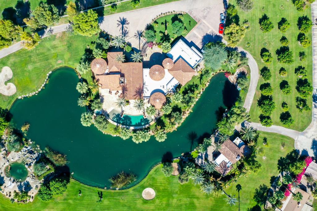 10,320 SF of livable space on 9.44 Acres operating as a Luxury Vacation Rental since May 2021. This is a one of a kind equestrian property with a 5 hole pitch and putt and is within walking distance to the New Golden Voice Festival Grounds, home of Coachella Fest and world renowned Eldorado Polo Club. Upon entering the custom iron gates of this beautifully maintained peaceful paradise, you can feel the stress of the day vanish This Narendra Patel designed estate offers a main home with 4 bedrooms, guest powder room and expansive chef's kitchen. The dining and living areas have four pocket windows that transform the areas into a breathtaking experience bringing together the serenity of the outside, in. The main home is surrounded by a pristine lake which offers a three tiered waterfall. Over the top 12-horse stables with interlocking paver floors and 2 pasture areas and an adorable chicken coop. A guest home with 2 ensuite bedrooms with central fireplace and kitchenette is a private area situated across the lake from the main home offering you and your guests privacy. An additional ''carriage house'' with a quaint 2 bedroom 1 bathroom apartment located upstairs of double garages. This manicured estate has caretaker quarters located on the south east corner of the estate. As you stroll around the grounds of this estate you will find an amazing organic orchard. Private well and canal water for irrigation. Luxury Vacation Rentals are operated by Avantstay