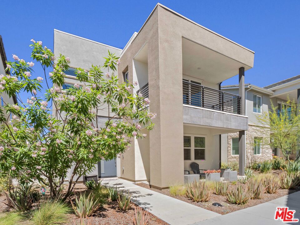 Experience the beauty of this nearly new Valencia Five Point home with 3 Beds, 2.5 Baths, complete with a spacious loft could make a 4th bed, solar, dual yards and 2 car garage. Designer touches throughout the residence creates an inviting ambiance, highlighted by a beautifully appointed kitchen and dining area featuring a shiplap wall design. The chef's kitchen boasts a glass tile backsplash and top-of-the-line stainless steel GE Monogram appliances, complemented by a custom center island with shiplap detailing and a convenient walk-in pantry. The living room is highlighted by a custom batten board wall, while the dining area features a large sliding door that opens to a meticulously manicured yard, adorned with a stylish light fixture. The bright and airy loft serves as a perfect retreat, while the primary suite offers a private balcony and a luxurious ensuite bathroom, complete with a soaking tub, a glass-enclosed walk-in shower, and a generous walk-in closet. Two additional spacious bedrooms share a full bathroom with dual sinks, and the upper level is completed by a well-appointed laundry room. Luxury vinyl plank flooring and upgraded window coverings add to the home's appeal, while solar panels enhance its energy efficiency. The dual fully landscaped yards feature a fully covered patio with a ceiling fan, perfect for outdoor entertaining. Located just minutes from the 5 Freeway, Highway 126, Six Flags Magic Mountain theme park, and all Valencia has to offer. Residents enjoy access to a weekly farmers market, spectacular resort-style pools with cabanas, gas barbecues, a children's play area, community gardens, walking and golf cart trails, and breathtaking mountain views throughout. Don't miss this opportunity to make this your New Home!!