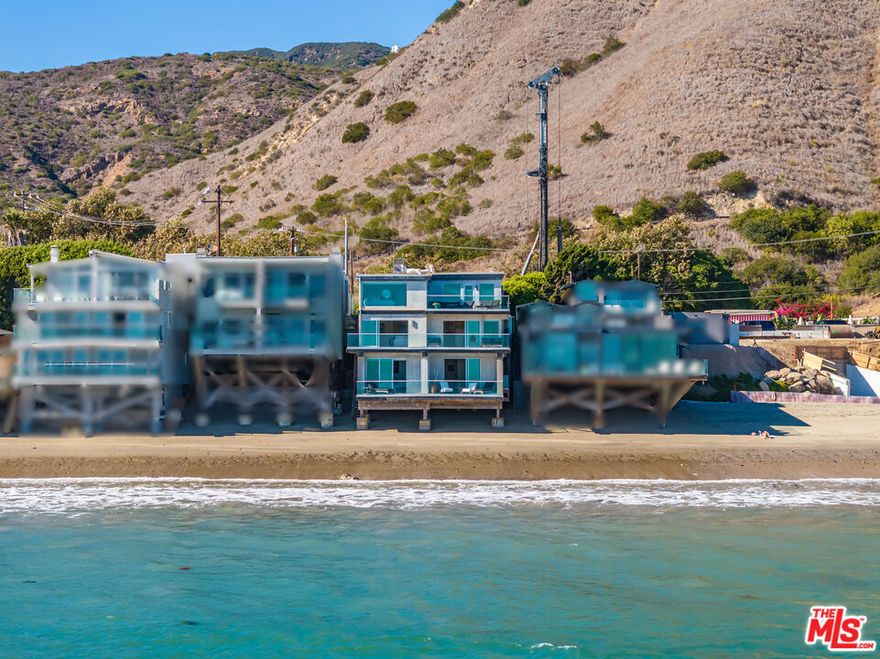 Discover unparalleled coastal elegance in this breathtaking oceanfront estate, perfectly poised on Malibu's pristine shores with direct beach access via a private staircase and mesmerizing 180-degree Pacific vistas. This contemporary three-level masterpiece offers four bedrooms, three and a half bathrooms, floor-to-ceiling glass walls that invite natural light to dance across every room, and multiple ocean-view terraces perfect for savoring sunsets or hosting intimate gatherings. The chef's kitchen, a culinary dream with top-tier appliances and sleek cabinetry, anchors the main residence, while an attached two-bedroom, one-bath guest suite with a full kitchen, washer/dryer, and private entrance provides a versatile retreat for guests or family. With a three-car garage plus parking for four or more vehicles, and a prime location steps from scenic hiking trails, vibrant restaurants, chic boutiques, and everyday essentials, this sanctuary blends modern sophistication, privacy, and the timeless allure of Malibu's coastal lifestyle.
