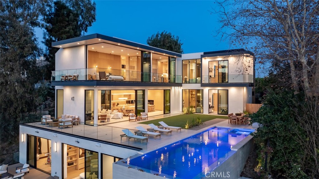 Introducing a masterpiece that seamlessly blends modern European architecture with natural materials, creating a timeless masterpiece in the legendary Bel-Air community. Designed as a living piece of art with interior design by James Rosen and architecture by Mauricio Duk from Studio MD. This 3 winged residence spans over 7,504 sqft, featuring 6 bedrooms, 9 bathrooms, home theater, gym, infinity pool, outdoor kitchen and two expansive decks that provide unparalleled outdoor living spaces. Enter through a grand 11-foot glass front door into a space that immediately reveals serene mountain and ocean views, radiant sunlight, and vibrant sunsets reflected in the sparkling waters of the 41-foot infinity pool and spa. Expansive ceilings and a sweeping open floor plan create an airy, welcoming ambiance. The great room, with its elegant living and dining areas feature a fireplace wrapped in silver travertine stone, flows effortlessly into a chef’s dream kitchen, featuring sleek Italian design paired with Miele appliances and a 15-foot island with seating. The bottom floor opens to a gorgeous deck, features a state-of-the-art home theater, a gym with a steam shower, wine cellar, living area with a gorgeous bar, powder bath and an additional bedroom with an en-suite bath. The crowning jewels of the home are the two decks with over 2,000 sqft, offering a complete outdoor living experience. The luxurious primary suite offers Jetliner ocean and canyon views from every angle. Walk into the spa like primary bathroom that offers ample space, sky lighting that exude natural light, a luxurious shower and an elegant basin tub. The walk-in runway closet with LED-lighting shelving will make your wardrobe look like an art gallery. Every aspect of this home exudes sophisticated design, master craftsmanship, and unparalleled attention to detail. With its modern aesthetic, cutting-edge amenities, and seamless integration of indoor and outdoor spaces, 1149 Linda Flora Drive is a true trophy home perfect for those seeking the pinnacle of luxury living.
