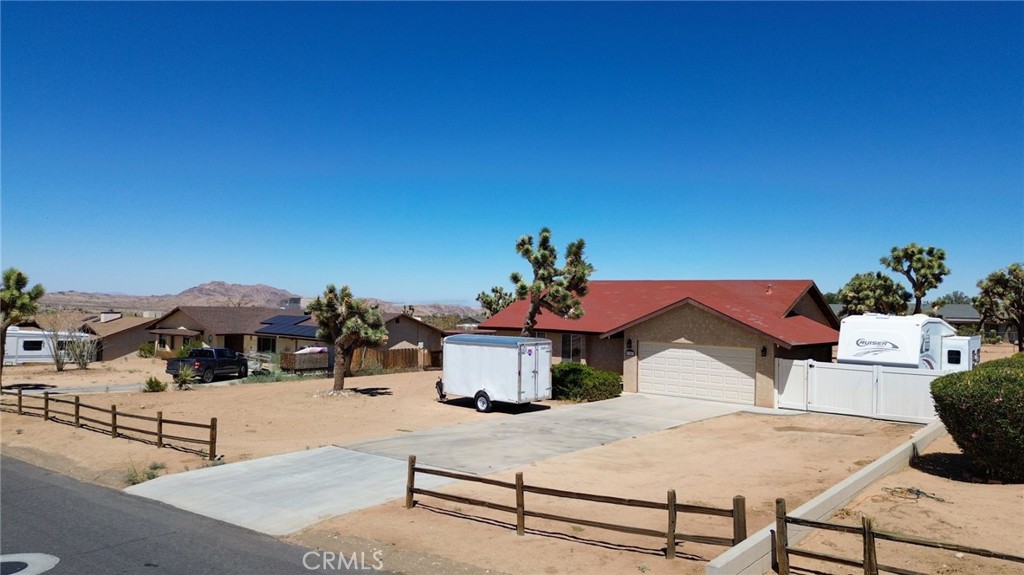 Welcome to this beautifully maintained 3 bedroom, 2 bath home sits on a large 0.41 acre lot in Western Hills Ranchos with stunning mountain views. Enjoy an open floor plan with bright living spaces and a spacious kitchen with bay windows. The fenced backyard is ideal for entertaining and outdoor living, featuring dedicated RV parking with full hookups, perfect for RV enthusiasts or extra storage. An attached 2-car garage and indoor laundry add convenience. Close to schools, shopping, and just minutes from Joshua Tree National Park—this home offers space, comfort, and the perfect desert lifestyle! Don't miss this opportunity!