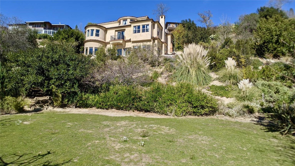 Tucked away seclusively on a private cul-de-sac off the Foothill Blvd. in La Canada Flintridge. Easily accessible by the 2 and 210 freeways. This property is located on one acre of premium land overlooking miles of spectacular downtown and mountains, and on a clear day Long Beach and Catalina Island! Within a mile of famous Descanso Gardens, and just eleven-minute drive to Rose Bowl Stadium, this immaculate, custom built Tuscany view home on gated, landscaped grounds has its own private driveway in the prestigious Foothills of La Canada! A short drive from downtown, this rarely available relaxing getaway delivers nature-surrounded living at its absolute finest and offers the ultimate retreat from city life. Perched high above the city, on a private road, you arrive to an exquisite home with unbeatable surrounding scenery and breathtaking views. This impressive 4 bedroom, 5 bathroom home was quintessentially crafted with designer touches and brings the best of Mediterranean sophistication and modern luxury. A formal foyer with a winding wrought iron staircase welcomes you and takes you through the living areas down to an entertaining area with fine-crafted coffered and beamed ceilings, a grand stone inlaid fireplace, wide plank wood flooring, elegant moldings, a formal dining room, and oval breakfast nook just off the entertainer's kitchen. With an abundance of windows and three levels of outdoor patios and balconies, you will enjoy jet-liner mountain and downtown views from almost every corner of the home. The light-filled, open layout seamlessly connects entertaining, dining, kitchen, and jacuzzi to the outdoors, creating an entertainer's dream setup for the quintessential indoor-outdoor lifestyle. The open chef's kitchen is built for entertaining and features Thermador appliances, custom cabinetry, walk-in pantry, seated island, breakfast nook, and leads to the formal dining room. The incomparable master suite boasts a marble faceted en-suite with two separate vanities, a glass-enclosed shower room, a raised spa, custom walk-in his and hers dressing rooms. The second master suite and additional bedrooms are equally equipped to make young ones or in-laws feel right at home. There is an office next to the bathroom on the lowest level that can be a 5th bedroom. A private elevator (Symmetry Hydraulic drive residential elevator, wheelchair accessible with a capacity of 1000 lbs) that will take you to all three stories has been installed.