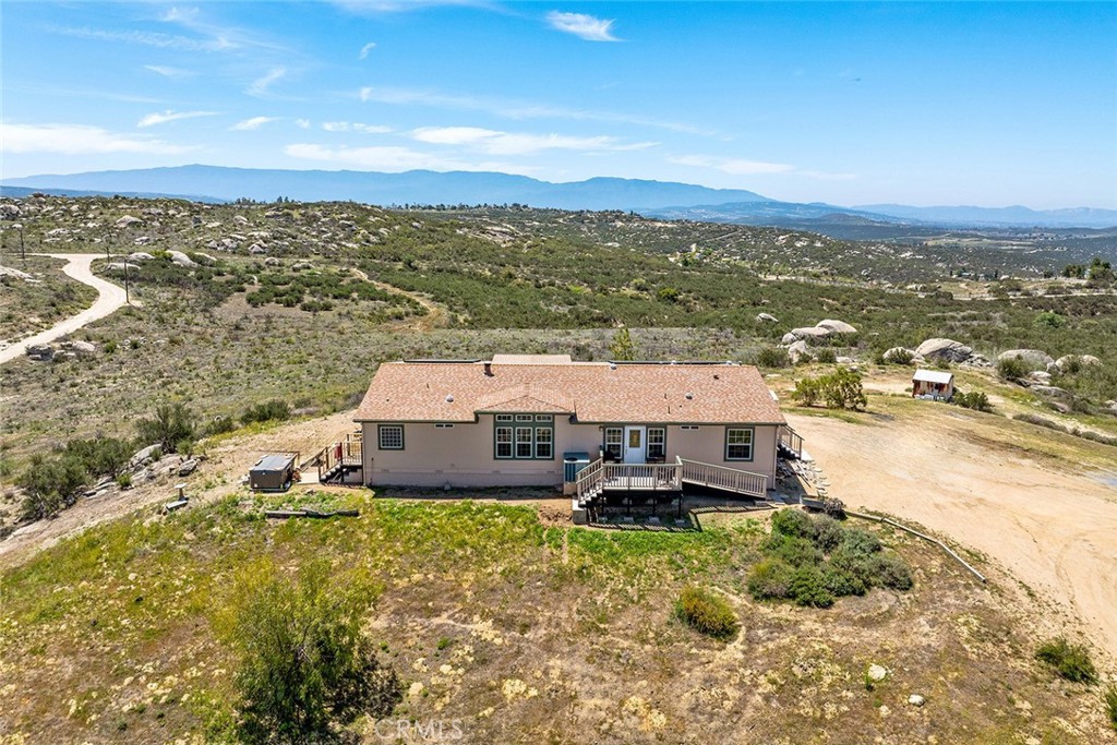 Per county you can add an ADU or two to this property! Private 21.33-Acre Horse Property with Stunning Mountain Views.
If you're looking for wide-open space, privacy, and breathtaking views in every direction—this place has it all. This 3,574 sq ft home, built in 2006, sits on over 21 acres with incredible 365-degree views of the surrounding Southern California mountains including Big Bear, San Jacinto, Mt. Palomar and more!
The home has 3 bedrooms and 3 full bathrooms, with a bright and open layout. The main living space features vaulted ceilings, a cozy wood-burning fireplace, and tons of windows that let in natural light and mountain views. The kitchen is spacious and super functional, with an island, breakfast bar, all the must-haves, a pantry, and room for two refrigerators. There's also a big dining area perfect for hosting, and a large laundry/mudroom with space for a freezer. The primary suite is massive, with its own sitting or office area, walk-in closet, private bathroom with dual sinks and a shower, and direct access outside to take in the Mt. San Jacinto views from your 2024 spa tub. For horse lovers, this property is ready to go:
- **95’x45’ mare motel** with 6–8 stalls (12x12 each) and turnouts DIRECTIONS; TAKE RED MT RD, DO NOT TAKE MINTO.
- **52’ round pen**
Other features include:
- **Two working wells**, (2) 5,000-gallon storage tanks, and fire hose hookup
- Home and well are wired for backup generator in case of power outage.
- **Leased solar system**
- Pad with power and plans ready for a **35’x25’ 3-car garage**
- Dual-zoned HVAC, 1,500-gallon septic, and **full RV hookups**
Zoning is R-1-5, on electricity, well and propane.
This is a peaceful, private spot with room to breathe, trails to ride, and enjoy nature—just bring your horses and your vision. Only 15 minutes to Diamond Valley Lake to fish and boat, Western Center Academy Charter School, Temecula Wine Country.