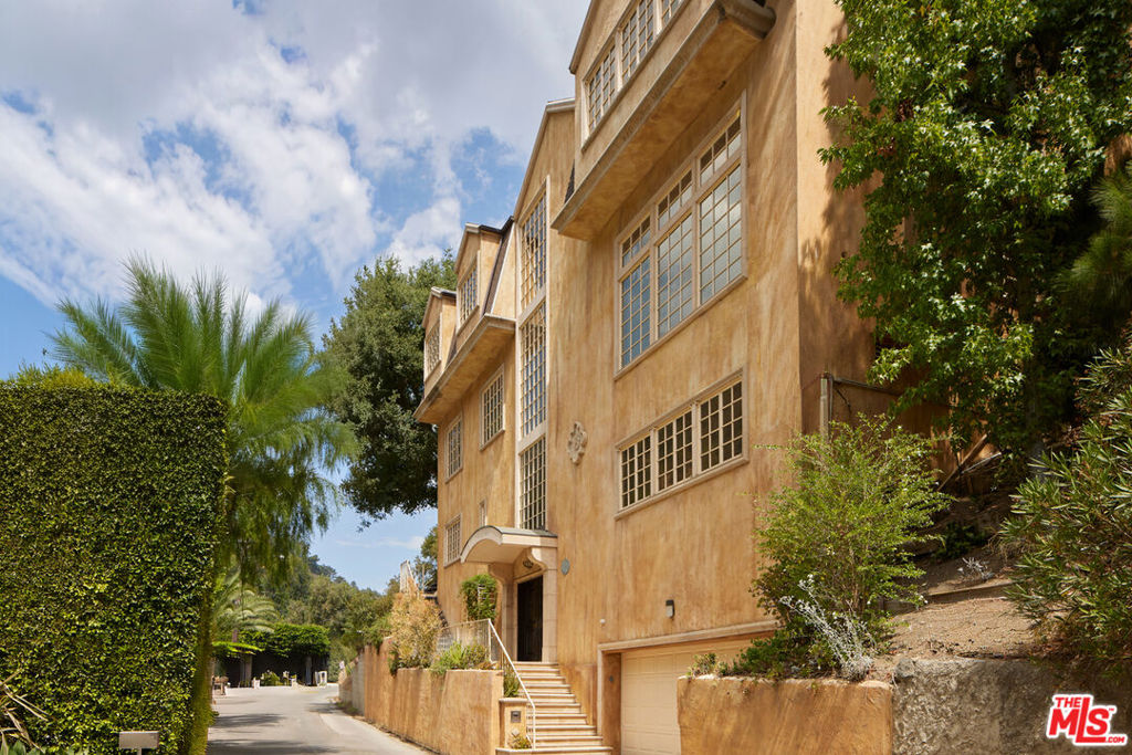Welcome to 1808 Franklin Canyon Drive - a rare opportunity to own a massive 4,335 sqft Italian Renaissance Revival home nestled in the heart of Beverly Hills Post Office, just minutes from Sunset Blvd yet surrounded by the serenity of Franklin Canyon. This expansive residence offers 4 bedrooms and 3.5 bathrooms with a thoughtfully defined layout with canyon and treetop views from nearly every room. The top floor boasts 3 bedrooms - a perfect setup for family living. The 4th bedroom on the first floor is ideal for guests or an au pair. The well-maintained elevator effortlessly connects all floors, from the garage to the top level, where you'll find a private outdoor space reminiscent of an Italian retreat. This exceptional home combines scale, location, and value - priced well below the average cost per square foot in Beverly Hills Post Office. This architectural home is ready for a designer's vision, offering a unique opportunity to personalize and add tremendous value to its spacious layout and incredible location. Step inside to find a home filled with natural light, high ceilings, wide hallways, and elegant real hardwood floors. The temperature-controlled wine cellar is a connoisseur's dream, while the large media space offers endless possibilities for entertainment, play, or an office. The property also features an updated fireplace in the primary suite, custom kitchen, living room with a custom wet bar and statement fireplace, and a spacious 2-car garage with considerable storage. Situated just a short walk to the beautiful Franklin Canyon trail and Coldwater Canyon Park, this home provides access to nature and tranquility while still being minutes away from the heart of Beverly Hills. Located in the coveted Warner Avenue Elementary School district. Unfurnished and ready for your pinterest board, this Beverly Hills charmer must be seen to be fully appreciated.