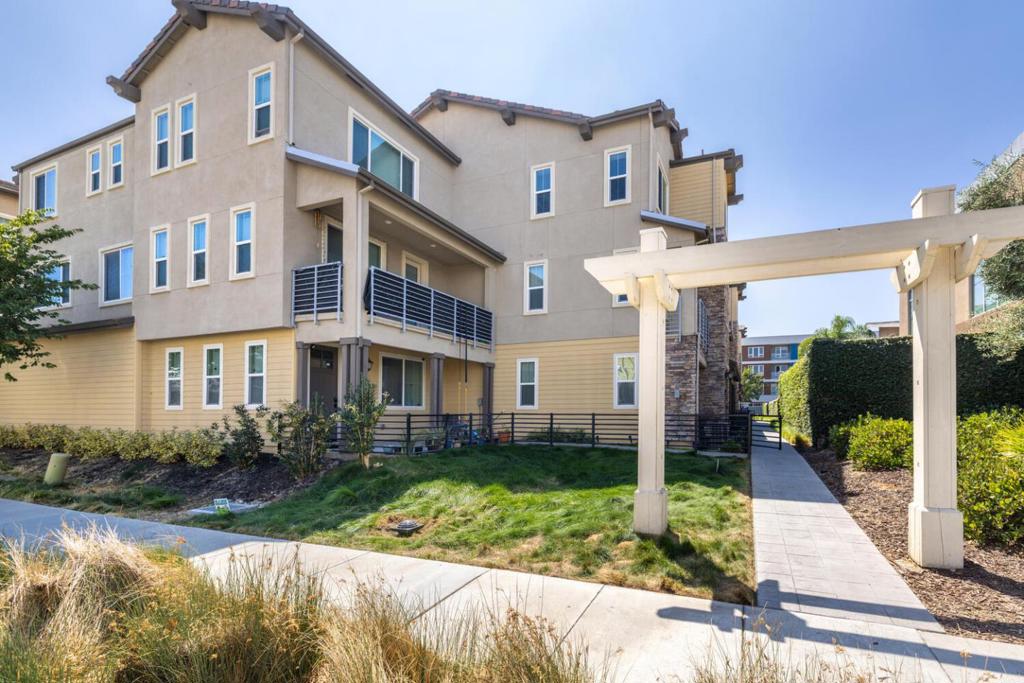 Welcome to this stunning Ellington-2 executive townhome, perfectly situated right next to a luxurious 12,000-square-foot clubhouse. This home offers an incredible blend of comfort and convenience. Open floor plan filled with natural light, highlighting the spacious living areas. The gourmet kitchen is a chef's dream, featuring granite countertops, a large island, and top of line stainless steel appliances including a gas stove. Walk-in pantry for ample storage. Designed for modern living with every bedroom featuring its own private full bathroom, including a versatile ground-floor bedroom that's perfect for a home office, guests, or roommates. 3-zone AC/heat to control the temperature on each floor, keyless entry, and an upstairs laundry room. Large balcony for entertaining and a cozy front porch patio. The primary suite is a true retreat with a spacious walk-in closet and a bathroom with dual vanities. Two-car garage is equipped with an EV outlet. Amenities include a giant pool, spa, gym, event center, lounges, fireplaces, and yoga and spin rooms. Enjoy outdoor gatherings at the community BBQ areas, playgrounds, and community gardens. Centrally located within easy access to parks, shopping, and highways 85 and 101, as well as the VTA Light Rail and major employment centers.