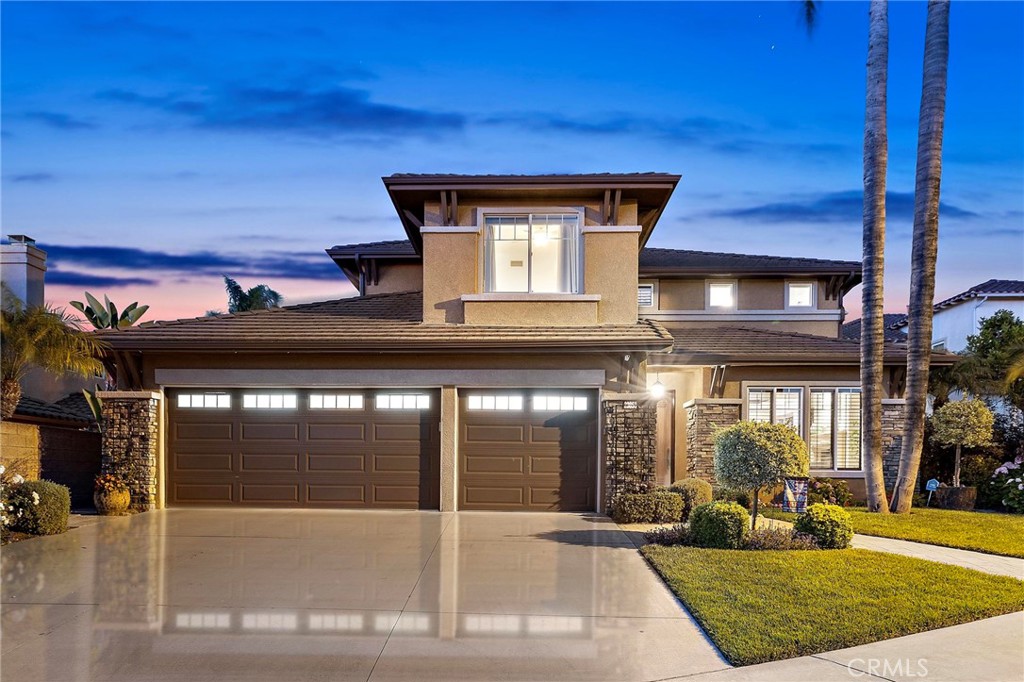 Step inside this welcoming home in the guard-gated Stoneridge neighborhood, where families enjoy peace of mind and exclusive access to Lake Mission Viejo. Located on a quiet single-loaded street adjacent to a greenbelt, this residence offers added privacy and a tranquil setting.
With five flexible bedrooms, 5.5 baths, and a spacious 4-car garage, this home offers both style and functionality. Bright natural light fills every room, creating a cheerful setting for busy days and relaxed evenings. Gather in the open dining and living rooms, centered around a cozy fireplace—a perfect spot for catching up after work or school. The downstairs includes a flexible office with its own closet and a full bathroom next door. This space easily transforms into a main-floor bedroom for guests or extended family when needed. The kitchen is truly the heart of the home. There’s a large center island for prepping dinners together, extensive cabinetry, a walk-in pantry for all your groceries, and wide views of the backyard—a great setup for keeping an eye on everyone at play. This space flows into an eat-in area and an extra-large family room, complete with built-ins and a second fireplace. Movie marathons, game nights, and family gatherings feel right at home here. Upstairs, the primary suite features vaulted ceilings, dual closet and master bath. Open the doors to your own private balcony and enjoy panoramic views of the city lights. Three additional bedrooms with ensuites complete the upstairs, providing space for everyone to recharge or work from home. The garage is one that will make any homeowner proud—offering ample storage and thoughtful organization, ready to handle hobbies, sports gear, or weekend projects with ease. The 4th car tandem garage is currently being used as a workshop. Outside, the backyard is ready for entertaining and outdoor fun with a covered cabana for al fresco dining, a built-in bar and BBQ, and a roomy, landscaped lawn for activities or gardening—all set against impressive city views. The home also features solar panels, ensuring energy efficiency and cost savings. A scenic hiking trail runs directly behind the property, providing easy recreation. Stoneridge residents benefit from access to exceptional schools, convenient shopping, and an abundance of entertainment option. This is a home designed to meet the needs of modern family living in one of Mission Viejo’s most sought-after communities.