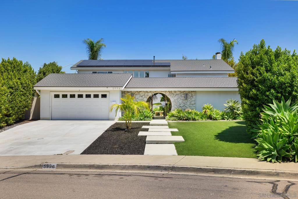 Welcome to 5996 Bounty Street, a stunning mid-century modern home nestled in the highly desirable community of Del Cerro. This spacious 5-bedroom, 3-bathroom residence sits on over a quarter-acre lot and has been thoughtfully upgraded to blend timeless design with contemporary style. A dramatic two-story vaulted entryway showcases a striking floating glass-and-wood staircase and restored 1965 Palm Springs double doors, setting the tone for the vintage-meets-modern aesthetic throughout. The recently remodeled kitchen features white shaker cabinets, newer appliances, and opens seamlessly to a bright and airy floor plan enhanced by luxury vinyl wide plank flooring and expansive windows that flood the home with natural light. The family room offers a cozy gas fireplace, perfect for relaxed evenings. Step outside to enjoy the resort-style backyard with a sparkling swimming pool, low-maintenance turf areas, fruit trees, raised garden beds, and a fire pit for entertaining. A covered patio and a spacious side yard provide multiple outdoor living options. The new concrete driveway and front steps enhance curb appeal, while the paid-for solar panels and new roof offer energy efficiency and peace of mind. Additional features include a tankless water heater, some dual-paned windows, and a 2-car garage with built-in storage cabinets. Zoned for top-rated schools and conveniently located near downtown San Diego, the airport, and beaches—this is California living at its best. It’s more than a home. It’s a Lifestyle!