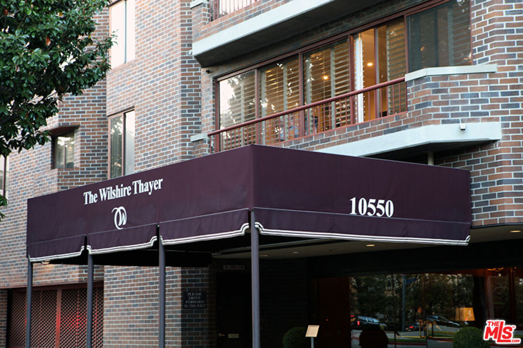 Welcome to The Wilshire Thayer where a luxurious, northwest-facing corner residence showcasing striking street and city views awaits you. This sophisticated two-story condominium features 2 bedrooms, 2.5 baths, approximately 2,146 sqft of living space, and elegant modern design throughout. Step inside to a formal entry leading to an expansive open-concept dining and living area with fireplace and framed by floor-to-ceiling glass which leads to a balcony overlooking the city. The gourmet kitchen boasts carrera marble countertops, custom cabinetry, a breakfast bar, and top-of-the-line Miele appliances. A den and stylish powder room complete the first floor, highlighted by sleek porcelain tile flooring throughout. A dramatic spiral staircase ascends to the upper level, where the spacious primary suite offers serene views, a fireplace, walk-in closet with safe, and custom built-ins. The primary bath includes a soaking tub, separate shower, dual vanity, and a dry bar with fridge. The junior suite offers its own full bath and overlooks the living area below and views through a striking NY loft-style glass. Plush carpeting throughout, laundry closet, and a convenient secondary entrance complete the upper floor. Perfectly located minutes from Beverly Hills, Century City, Westwood Village, UCLA, and places of worship, this residence combines refined living with exceptional convenience.