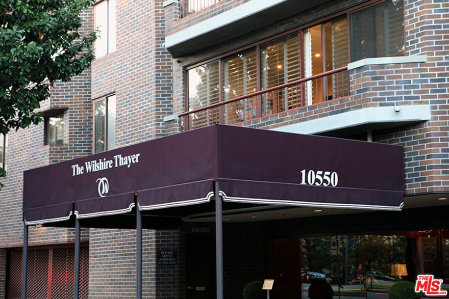 Welcome to The Wilshire Thayer where a luxurious, northwest-facing corner residence showcasing striking street and city views awaits you. This sophisticated two-story condominium features 2 bedrooms, 2.5 baths, approximately 2,146 sqft of living space, and elegant modern design throughout. Step inside to a formal entry leading to an expansive open-concept dining and living area with fireplace and framed by floor-to-ceiling glass which leads to a balcony overlooking the city. The gourmet kitchen boasts carrera marble countertops, custom cabinetry, a breakfast bar, and top-of-the-line Miele appliances. A den and stylish powder room complete the first floor, highlighted by sleek porcelain tile flooring throughout. A dramatic spiral staircase ascends to the upper level, where the spacious primary suite offers serene views, a fireplace, walk-in closet with safe, and custom built-ins. The primary bath includes a soaking tub, separate shower, dual vanity, and a dry bar with fridge. The junior suite offers its own full bath and overlooks the living area below and views through a striking NY loft-style glass. Plush carpeting throughout, laundry closet, and a convenient secondary entrance complete the upper floor. Perfectly located minutes from Beverly Hills, Century City, Westwood Village, UCLA, and places of worship, this residence combines refined living with exceptional convenience.