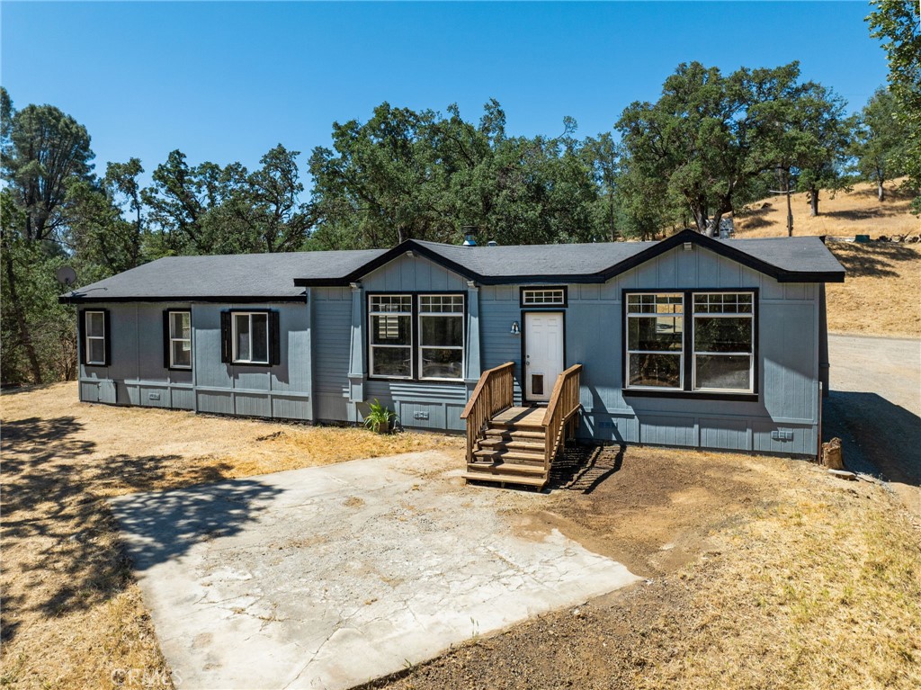 Lower Lake Ranchette is ready for horses! This private and secluded property is fully fenced and cross-fenced. It features a spacious 3-bedroom, 2-bath manufactured home with a barn, situated on just over 5 acres. The home is clean and fresh, showcasing newer floors, new exterior paint and siding, and a new HVAC system installed in 2024. It includes a carport and features a light, airy interior with sun tubes and large windows that provide views of the property from every room. The spacious kitchen offers ample storage, a kitchen island with a breakfast bar, and a dining area. It has a propane cooktop, built-in propane wall oven, microwave, garbage disposal, and dishwasher. The living room is warm and inviting, featuring a cozy wood stove on a raised hearth. There are two generous sized guest bedrooms, a guest bath, and a primary bedroom with a walk-in closet that includes a bathroom with a garden tub, walk-in shower, and dual sinks. There's also an indoor laundry room/mud room. The two-stall barn includes runs, water service, a tack room, hay storage, a breezeway with an overhang, a wash rack with stocks, and a riding ring. Detached covered hay storage. Numerous oak trees dot the property, and it has city water as well as an undeveloped well. Roads provide easy access throughout the property.