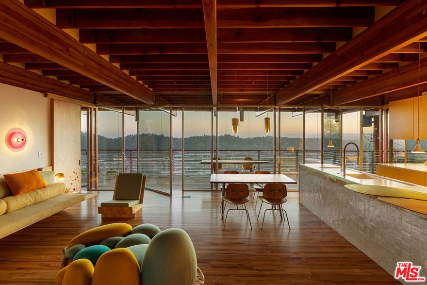 First offering: The Cano Residence, designed by Diego Cano-Lasso, is a true labor of passion. This impressive example of modern architecture captures the essence of Southern California's design ethos. Set in the scenic southwest hills of Mount Washington, the home features stunning city views that are integral to its identity. The striking wooden beams float above the Elysian Valley, while the glass-enclosed interior creates an intact connection with the outdoors. The beams extend outward, framing expansive vistas and leading to a tranquil garden that serves as a private sanctuary. Here, you can enjoy panoramas from the living area while being surrounded by nature. The spacious, sunlit room seamlessly flows into the dining area and large, open-concept kitchen, all of which highlight stunning twilight sunsets. The upper level features a wrap-around terrace with built-in bench seating. Imported Moroccan zellige tile has been expertly hand-laid to reveal one-of-a-kind, imaginative patterns. The home is adorned with red oak flooring and radiata pine throughout, adding to its alluring atmosphere. Bespoke hand-built furniture adds to the playful design, promoting comfort and creativity. Surrounded by vibrant flowers, hawks, hummingbirds, and the soothing sound of a trickling fountain, this space embodies the essence of home. Photography courtesy of Cameron Carothers. Long-Term, Furnished Lease.