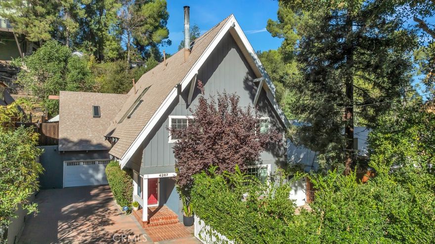 Welcome to Your Storybook Modern Farmhouse Retreat in Woodland Hills! Tucked away amid the natural beauty of Woodland Hills, this storybook modern farmhouse blends rustic charm with contemporary elegance. Every detail has been thoughtfully curated to create a warm, inviting, and luxurious home.The heart of the home is the stunning open-concept chef’s kitchen, featuring Carrera marble countertops, abundant cabinet and counter space, a double farmhouse sink plus a second prep sink, and a commercial-grade Wolf 8-burner range with double ovens and a custom hood. A full-height tiled backsplash, reclaimed wood barn door, and designer farmhouse light fixtures complete the picture-perfect look. The formal dining room opens seamlessly to the spacious living room, where reclaimed wood accents and a circular vintage fireplace set a cozy yet sophisticated tone. Custom wood flooring flows throughout, creating a sense of continuity and warmth. Upstairs, the primary suite offers a peaceful retreat with a large walk-in closet and a spa-inspired ensuite bathroom featuring a soaking tub, walk-in double shower, and custom finishes. Three additional bedrooms share an updated farmhouse-style bathroom, while a fifth room serves as a perfect space for a bedroom, office, gym, playroom, or meditation area featuring two sky lights providing beautiful sunlight and direct access to a private outdoor deck. Step outside to discover a true backyard sanctuary. Enjoy a cascading waterfall, expansive outdoor BBQ area with quartzite countertops, stainless steel sink, refrigerator, burner and seating for ten. Multiple lounging and dining areas invite you to entertain or unwind surrounded by nature. A second elevated terrace is ideal for morning yoga, coffee, or quiet reflection. Additional features include: Laundry area and powder room. Two-car attached garage, with EV charger. Tranquil views from every room in the house, an enclosed front and backyard sanctuary, newer AC unit, dual AC, newer water heater, Aquasana full-house and reverse osmosis water filtration systems, custom blackout curtains, vintage glass door knobs, and upgraded ducting. Rarely does a home with this much character, quality, and serenity come on the market. Conveniently located near The Village at Woodland Hills, The Commons at Calabasas, top-rated schools, fine dining, entertainment, and just minutes from the beach. Experience the perfect balance of nature, elegance, and modern living — your dream home awaits!