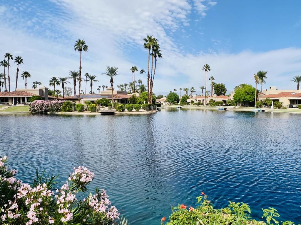 Nestled within the heart of Lake Mirage, this beautifully updated 3-bedroom, 3-bath residence combines comfort, elegance, and resort-style living. Step inside to a light-filled, open floor plan featuring tile and wood-look flooring throughout, classic wood shutters, and soaring cathedral ceilings. A double-sided fireplace warms both the living and dining areas, creating an inviting atmosphere for relaxing or entertaining. Expansive windows frame panoramic views of the lake and surrounding mountains, while the spacious patio invites you to enjoy tranquil mornings or sunset gatherings by the water. The primary suite offers peaceful lake views, a generous walk-in closet, and a luxurious ensuite bath complete with jetted tub and separate shower. Each bedroom features direct access to its own bathroom, ensuring privacy and convenience for all. This highly desired floor plan offers the ease of single-level living--no interior steps--and includes an assigned dock, perfect for a small electric boat or kayak. Located within the prestigious Lake Mirage Racquet Club, residents enjoy world-class amenities including 25 acres of open lake for sailing and rowing, scenic jogging and cycling paths, 10 tennis courts, 2 pickleball courts, 11 pools and spas, a fitness center, and a clubhouse ideal for private gatherings. All set within a guard-gated community just minutes from premier shopping, fine dining, and top-rated healthcare in the heart of Rancho Mirage.