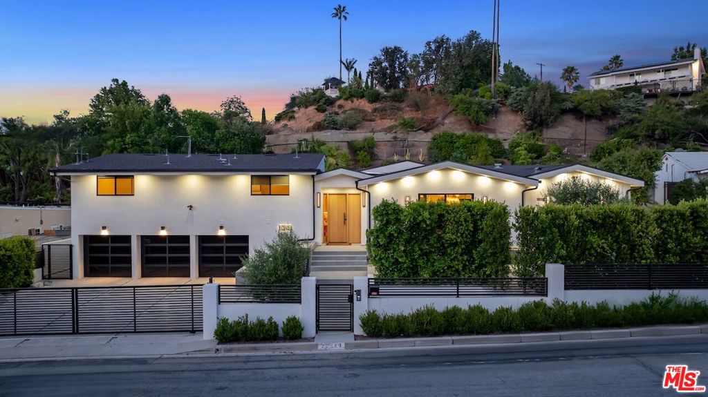 Welcome to 20226 Lorenzana Drive, a privately gated estate in the coveted Vista De Oro neighborhood of Woodland Hills. This 5-bedroom, 5-bathroom residence spans over 4,300 square feet of elevated living space on a lush 17,800+ square foot lot, offering privacy, sophistication, and seamless indoor-outdoor flow. Step through the dramatic steel and glass pivot door into a light-filled interior marked by soaring beamed ceilings, wide-plank wood floors, and custom finishes throughout. The open-concept floor plan connects spacious living and dining areas to a gourmet chef's kitchen featuring a large center island, sleek cabinetry, and top-tier appliancesperfect for both daily living and upscale entertaining. The expansive primary suite is a serene retreat, complete with a spa-style bath, oversized shower, soaking tub, and custom walk-in closet. All additional bedrooms are generously sized with en-suite access . Outdoors, enjoy a true resort-style backyard with a sparkling pool and spa, surrounded by mature landscaping and multiple areas for lounging and dining. Located south of Ventura Boulevard, this exceptional home is moments from top-rated schools, high-end shopping, and fine dining. 20226 Lorenzana Drive is the ultimate blend of comfort, style, and California luxury living