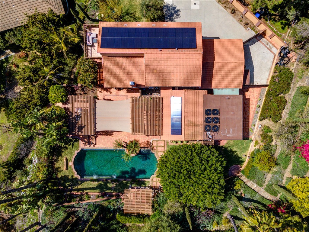 This Spanish-style home is a luxurious retreat, surrounded by lush green lawns and offering exceptional outdoor living spaces, including a saltwater pool, spa, fountain, and a BBQ island with an outdoor kitchen and dining area—perfect for entertaining. A detached guest house provides a private bedroom and bathroom with its own access and split-unit AC, making it perfect for grown children or elderly parents. Inside, the double door entry leads to the living room, featuring a modern fireplace, travertine flooring, and an open-beamed ceiling. The oversized family room continues the open-beam theme, with travertine floors throughout the first floor. The gourmet kitchen is equipped with granite countertops, a stone backsplash, and stainless steel appliances, and it flows into the breakfast nook. The master suite is a private retreat, featuring a balcony with pool views, a retractable awning, and city light views. The master bath offers dual sinks, granite counters, a six-foot Jacuzzi tub, and a mirrored closet. Two additional upstairs bedrooms have wood floors and mirrored closets, while the upgraded bath has a pedestal sink and black-accented tile. The downstairs guest bath also features a pedestal sink and a beautifully designed shower. The home includes a downstairs bedroom and is finished with crown molding and ceiling fans in the bedrooms for added comfort. The beautifully landscaped grounds are complemented by stunning lighting, large potted plants, and a garden with fruit trees. This home also includes RV parking, solar panels, an electric car charger, and a garage with epoxy floors. With too many amenities to list, this home is a must-see and offers the perfect blend of luxury and comfort.