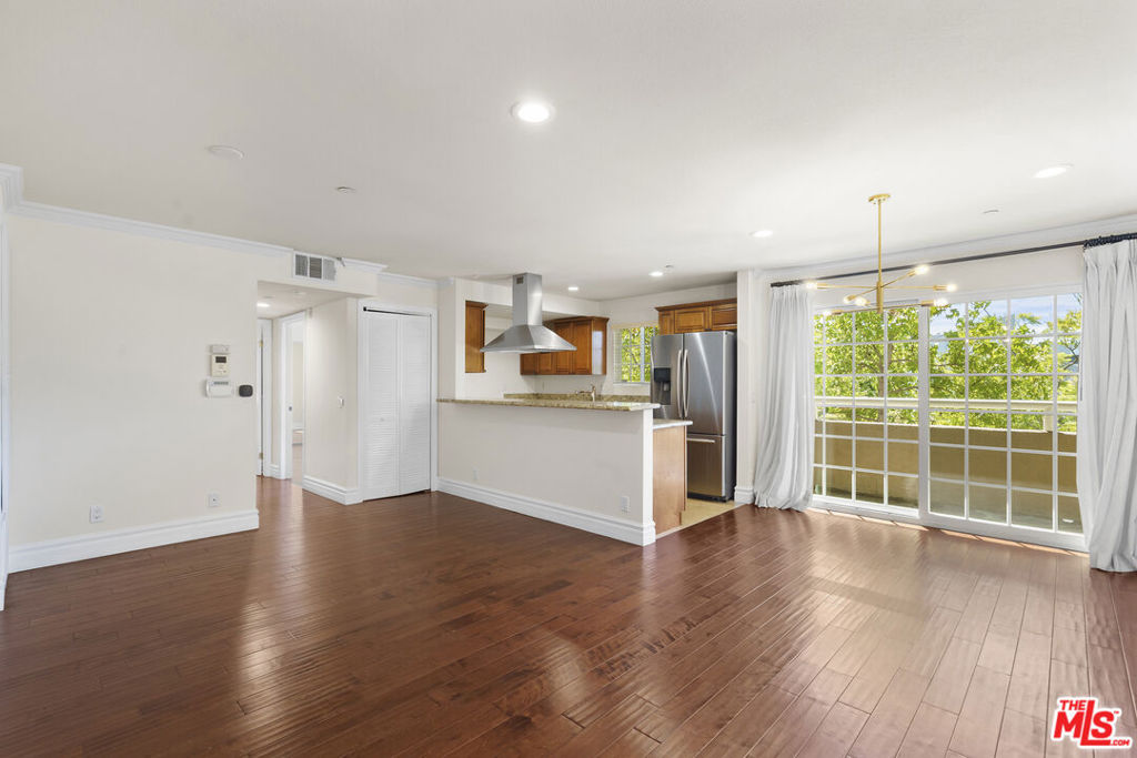 Don't miss this rare opportunity to own a spacious 3 bedroom, 2 bathroom corner condo in one of the most convenient and desirable locations near Korea-town, Hollywood, and the 101 Freeway. Perfectly situated close to popular markets, restaurants, and shops, this home offers not only an incredible price point but also unbeatable everyday convenience. The building is clean, well cared for, and maintained with pride all while offering a low HOA fee.This southeast-facing corner unit welcomes you with warmth and natural light throughout the day. The living room opens to a south-facing balcony, where the gentle sunlight streams through, filling the home with a cozy and inviting atmosphere. Whether you are enjoying your morning coffee, relaxing after work, or simply admiring the tree-lined views, the natural brightness enhances the comfort and beauty of the interior. Inside, the floor plan has been thoughtfully designed with no wasted space every square foot is functional and well used. The open concept layout connects the living room, dining area, and kitchen seamlessly, creating a spacious and airy environment that is perfect for both everyday living and entertaining guests. The front-facing windows bring in fresh air and tree views, adding to the refreshing and open feel of the space. The unit features beautiful engineered hardwood flooring throughout the main areas, recessed lighting, and the convenience of an in-unit washer and dryer. Recently painted interiors make this home truly move-in ready. The kitchen is positioned to maximize natural light and ventilation, offering an enjoyable space to cook and gather. With three well-sized bedrooms and two full bathrooms, this home provides versatility and comfort for families, couples, or even those looking for extra space to use as an office or guest room. The master suite is private and well-proportioned, while the secondary rooms are equally bright and functional. Altogether, this condo combines space, natural light, modern updates, two parking and convenience at an exceptional value. If you've been searching for a move-in ready home with a welcoming atmosphere and unbeatable location, this is the one you've been waiting for.
