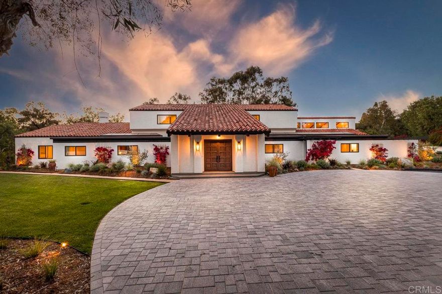 Positioned in the heart of Rancho Santa Fe’s historic Covenant, 6449 Las Colinas stands as a refined Spanish Modern estate—where timeless architecture is reimagined for today’s lifestyle. Recently renovated from the main residence to the guest house, every space showcases a balance of classic design and contemporary sophistication.  A circular drive introduces the home with a graceful arrival, highlighting smooth white stucco walls, espresso-framed windows, and mature landscaping. Inside, natural light pours through expansive windows and sliding doors, accentuating European oak floors, custom cabinetry, and open-beamed ceilings that lend warmth and character.  The chef’s kitchen is the centerpiece, appointed with Wolf and Sub-Zero appliances, an oversized island, and effortless connection to the dining and living spaces—ideal for both entertaining and day-to-day living. Multiple fireplaces, curated finishes, and seamless indoor-outdoor flow elevate the atmosphere throughout.  Resort-style amenities define the grounds, with a private pool, full-size tennis court, and a detached guest house offering luxurious accommodations for visitors or extended stays. Every element has been thoughtfully designed to maximize comfort, privacy, and connection to the outdoors.  The primary suite is a private retreat with vaulted ceilings, spa-inspired bath, and direct access to the backyard sanctuary. Designer lighting, high-end fixtures, and a versatile floor plan complete the home’s elevated living experience.  As part of The Covenant, residents enjoy direct access to miles of equestrian trails, the Rancho Santa Fe Golf Club (social membership included others require separate membership(s)), award-winning Roger Rowe School, and the community’s unmatched lifestyle—without the restrictions of a gated enclave.  A rare offering where historic Spanish charm and modern refinement meet in one of Southern California’s most coveted addresses.