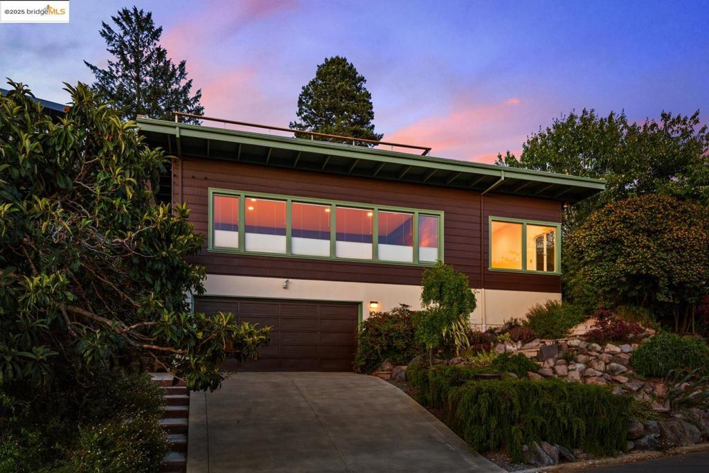 Enjoy sweeping, unobstructed views of SF and the Golden Gate Bridge from nearly every room of this stunning mid-century home - an architectural gem nestled on a tranquil, private street in the Berkeley Hills. Dramatic, light-filled living rm with soaring ceilings + massive view windows on both sides, creating a breathtaking indoor/outdoor feel. State-of-the-art modern kitchen complements the space with sleek finishes + intelligently designed features that blend style and function. Serene primary suite offers a spa-worthy bath and tall ceilings that enhance the sense of space and calm. Upstairs - large rooftop deck w panoramic vistas for sunset gatherings or quiet mornings with coffee + sky. Thoughtful indoor-outdoor flow continues w spacious front patio framed by lush landscaping + mature plantings - a natural sanctuary for entertaining or relaxing in complete privacy. Generous two-car garage + magnificent workshop area provide exceptional utility. Tucked just moments from the trails of Tilden Park and minutes to downtown Berkeley, shops, and restaurants, this exceptional home is the perfect blend of quiet retreat and urban access.
