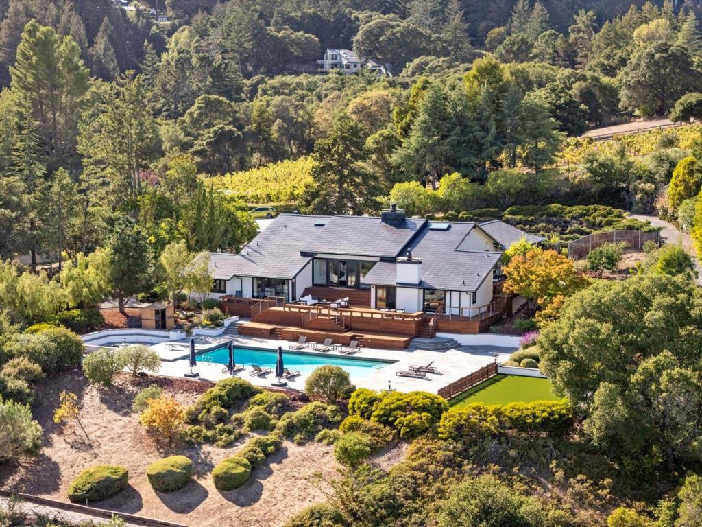 Sweeping views across the San Francisco Bay take center stage at this beautifully remodeled home on more than 3 acres of predominantly level land. Designed for entertaining and recreation, the property features a large pool and separate spa framed in Connecticut bluestone, an expansive synthetic lawn for recreation and play, and broad decks with built-in seating and cable-strung railings.  A brick-walled garden courtyard with Art Deco metal and glass front doors introduces the interiors highlighted by soaring ceilings and skylights. Wall-to-wall windows capture the panorama of the glorious views immediately upon entering. Multiple gathering spaces include a dramatic living room with stone-clad fireplace, a remodeled kitchen and dining area, and a family room with full bar and fireplace. A flexible use room between the foyer and kitchen offers versatility for a home office or playroom. Four bedrooms in a separate wing include a spacious primary suite with Bay views and steam shower, three bedrooms and a remodeled bath, plus there are two half-baths. Solar power with four Tesla Powerwalls, reclaimed San Francisco cobblestone paths, and a three-car garage are added features. Highly Rated Portola Valley Schools.  Minutes to Woodside Village.