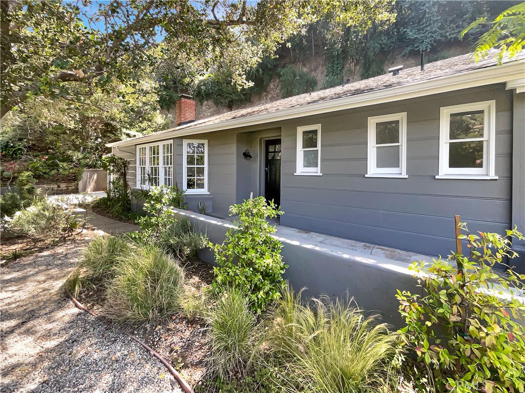 Set high in the Hollywood Hills, this inviting home offers the perfect balance of privacy, comfort, and city convenience. Expansive picture windows fill the living and dining areas with natural light, highlighting hillside views and a warm fireplace that anchors the space. The updated kitchen is appointed with sleek cabinetry, counters, and upgraded appliances, while generously sized bedrooms include a peaceful primary suite. Surrounded by lush landscaping, the property creates a tranquil retreat ideal for relaxing or entertaining, yet remains just minutes from Griffith Park, the Hollywood Sign, and the dining and shopping of Franklin Village and Los Feliz. A rare chance to experience both privacy and proximity in one of Los Angeles’s most iconic neighborhoods.