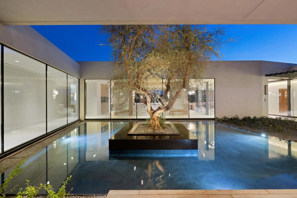 Experience the ultimate in luxury living at this stunning estate in the prestigious Madison Club. This exquisite property offers 7 bedrooms, 7.5 baths, and 10,046 square feet of living space, with panoramic views of the Santa Rosa Mountains and the 4th hole of the renowned Tom Fazio-designed golf course. This home is a masterpiece of design and craftsmanship, featuring top-of-the line finishes and amenities, such as a golf-simulator room, an office/home gym, art hallways, and a well-appointed bar and wine cellar. Enjoy breathtaking panoramic views by the cozy fireplace in the spacious great room or unwind in the opulent primary bedroom suite, complete with fireplace, sauna and steam room. The gourmet kitchen is a chef's dream, equipped with a prep kitchen and a large pantry. The floor to ceiling glass doors pocket away to create a seamless transition from indoor to outdoor living areas, where you can enjoy the outdoor fire features, the infinity edge pool, the spa, and the built-in barbecue. The separate living upstairs offers privacy and comfort, with two bedrooms, two baths, a living area, a kitchen, and an outdoor lounge area with a fireplace and endless 360-degree views of the desert. This home is a rare opportunity to own a piece of paradise in one of the most exclusive communities in the desert. Don't miss this chance to live your dream at the Madison Club.