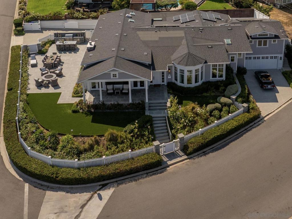 Welcome to this breathtaking Cape Cod nestled in the heart of Point Loma, where coastal elegance harmonizes with modern luxury. This exquisite home boasts an open-concept interior with soaring ceilings, intricate coffered details, and expansive transom windows that bathe the space in radiant natural light. The gracious dining area flows effortlessly into a cozy living room featuring a charming fireplace and stunning bay views. Step outside to a beautifully landscaped patio, complete with a glowing fire pit and a serene outdoor dining area—ideal for enchanting gatherings or tranquil moments savoring the coastal breeze. Modern features pair with this classic design for a one of a kind home.
