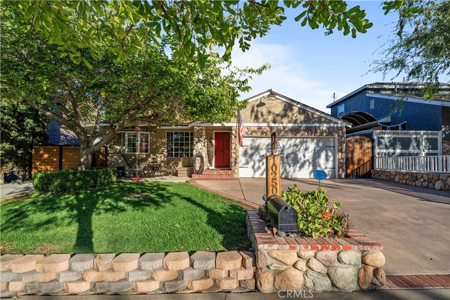 Welcome to 10250 Quill Avenue, a warm and inviting home set on a quiet, neighborly cul-de-sac. The street is wide, well kept, and lined with sidewalks on both sides, adding to the open, welcoming feel of the neighborhood. The curb appeal draws you in right away, with stone and wood accents, a charming front porch area, and a mature tree that shades the front yard and adds privacy. There is additional parking with two concrete driveways and extra space along the side of the home as well as a RV dump station.

The moment you step inside, you’re greeted by the charm of wood beams and vaulted ceilings that bring richness and warmth to the open living space. The living room flows naturally into the dining area and kitchen, creating an easy layout that feels both functional and welcoming. Recessed lighting throughout the home adds a soft, modern touch and enhances the inviting atmosphere. A central hallway leads to three bedrooms, two updated bathrooms, and direct access to the finished garage.

The primary suite is what makes this home stand out. A spacious retreat with vaulted wood ceilings, Saltillo tile floors, and a stone fireplace that fills the room with warmth and character. A bonus room off the primary, currently used as a hair salon, offers flexibility for a home office, studio, or creative space. The private bathroom offers a walk-in shower, dual vanity, and wood accents for a warm, modern touch. The suite provides direct access to the backyard, along with a separate door to a private patio tucked behind the home, perfect for quiet mornings or evening unwinding.

Designed for relaxation and fun, the backyard includes lush landscaping, a built-in fire pit, a large putting green, a spa, and landscape lighting that creates an inviting ambiance. Bistro lights add a soft glow across the patio, setting the perfect mood for entertaining.

10250 Quill Avenue is a rare find combining charm, practicality, and a true sense of home in one of Sunland’s most peaceful, community-oriented pockets.