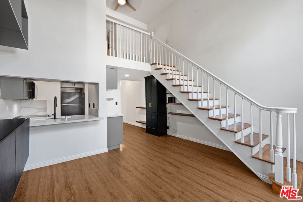 Welcome to luxurious boutique living at 1440 Veteran Avenue, a resort-style community in the heart of Westwood. This beautifully remodeled third floor, two level loft is available for a one year lease and offers the perfect blend of modern sophistication and serene comfort. Soaring vaulted ceilings create an airy, open atmosphere, complemented by a charming Juliet balcony that brings in natural light and fresh air. The living room features dramatic two story windows that showcase views of the green, tree lined side street of Kelton Avenue, adding a peaceful, scenic backdrop to your daily living. The updated kitchen features sleek quartz countertops, modern cabinetry, stainless steel appliances, a workstation sink, and a custom built in bar with an adjacent pantry for added storage. The spacious living area includes thoughtfully designed built ins, ideal for an entertainment center, extra storage, or showcasing your favorite pieces. Upstairs, the loft style bedroom offers two closets and a ceiling fan for year round comfort. The newly renovated bathroom is a showstopper, with a large walk in shower, bidet toilet, heated towel bar, and generous storage space. Luxury vinyl plank flooring runs throughout the unit, adding a cohesive and contemporary touch. Resort style amenities abound, enjoy 24 hour security, a new secure fob entry system, digital package check in, on site management, and a state of the art fitness center with Precor machines, StairMaster, and free Peloton classes. Relax in the steam room, sauna, or at the chic resident lounge with catering kitchen and party space. Step outside to a lushly landscaped courtyard featuring koi ponds, peaceful waterfalls, friendly turtles, a heated pool, and a spa, your very own urban oasis. Located just moments from UCLA, Westwood Village, and the upcoming Purple Line Metro station, the complex is also across the street from a sprawling park with tennis and basketball courts, soccer fields, and a dog park. A rare highlight is the two car tandem parking space, one of the largest in the building, offering exceptional convenience and flexibility. On site EV charging stations add to the ease of living. All utilities are included in the rent, and this exceptional unit is available for immediate move in, schedule your showing today!