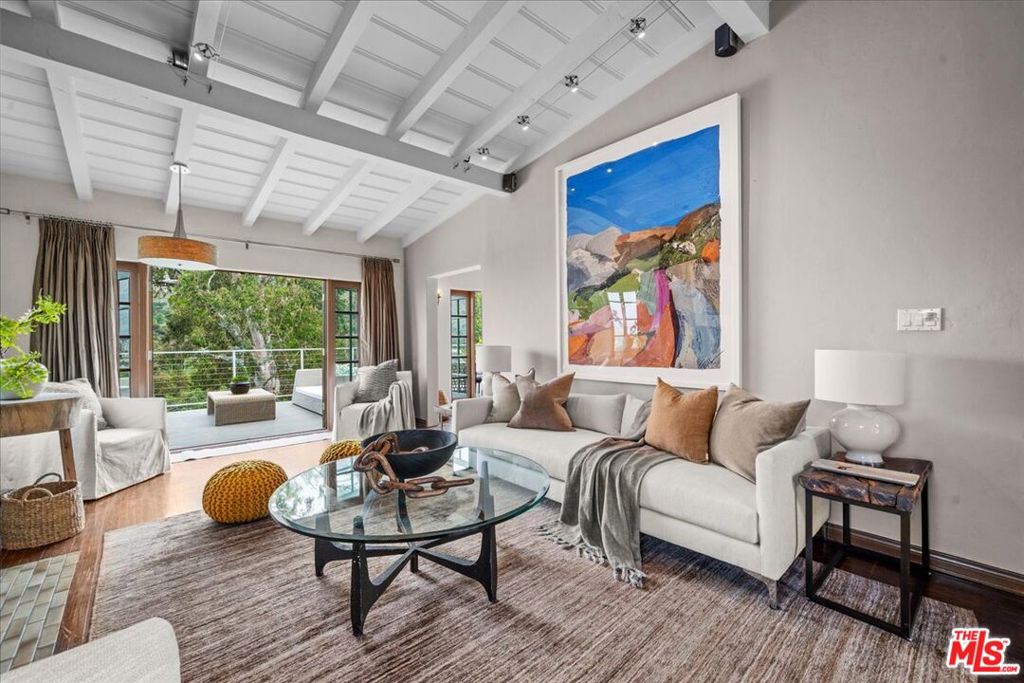 Savor gorgeous views all day long from this alluring Hollywood Hills Spanish home with French doors to a charming brick entry courtyard at the front & spacious view decks that extend the living space outdoors in the back. Inside, the dramatic living room boasts a high beamed ceiling, an elegant decorative tiled floor to ceiling fireplace & rich hardwood floors. Adjacent, one side of the the dining area opens with French doors to the balcony while the others side is open to the kitchen with handsome custom cabinetry, stone countertops, upscale stainless steel appliances, a hammered copper farm sink & breakfast bar. A sweet den/4th bedroom upstairs next to a charming tiled bath also has a high beamed ceiling & classic alcove bookshelves. A curved staircase lit with period sconces leads to the lower level with 2 bedrooms (or office) + a romantic master retreat with a chic decorative fireplace & French doors that open to the lower level balcony. The terraced backyard with manicured mature trees provides more outdoor hang out, play & garden areas. Nearby, enjoy the miles of hiking trails in Griffith Park & around the lovely Lake Hollywood Reservoir. This ideal location connected to nature is an easy commute to most major studios, downtown, Hollywood, Pasadena & the San Fernando Valley. Also for lease for $6,990 per month.